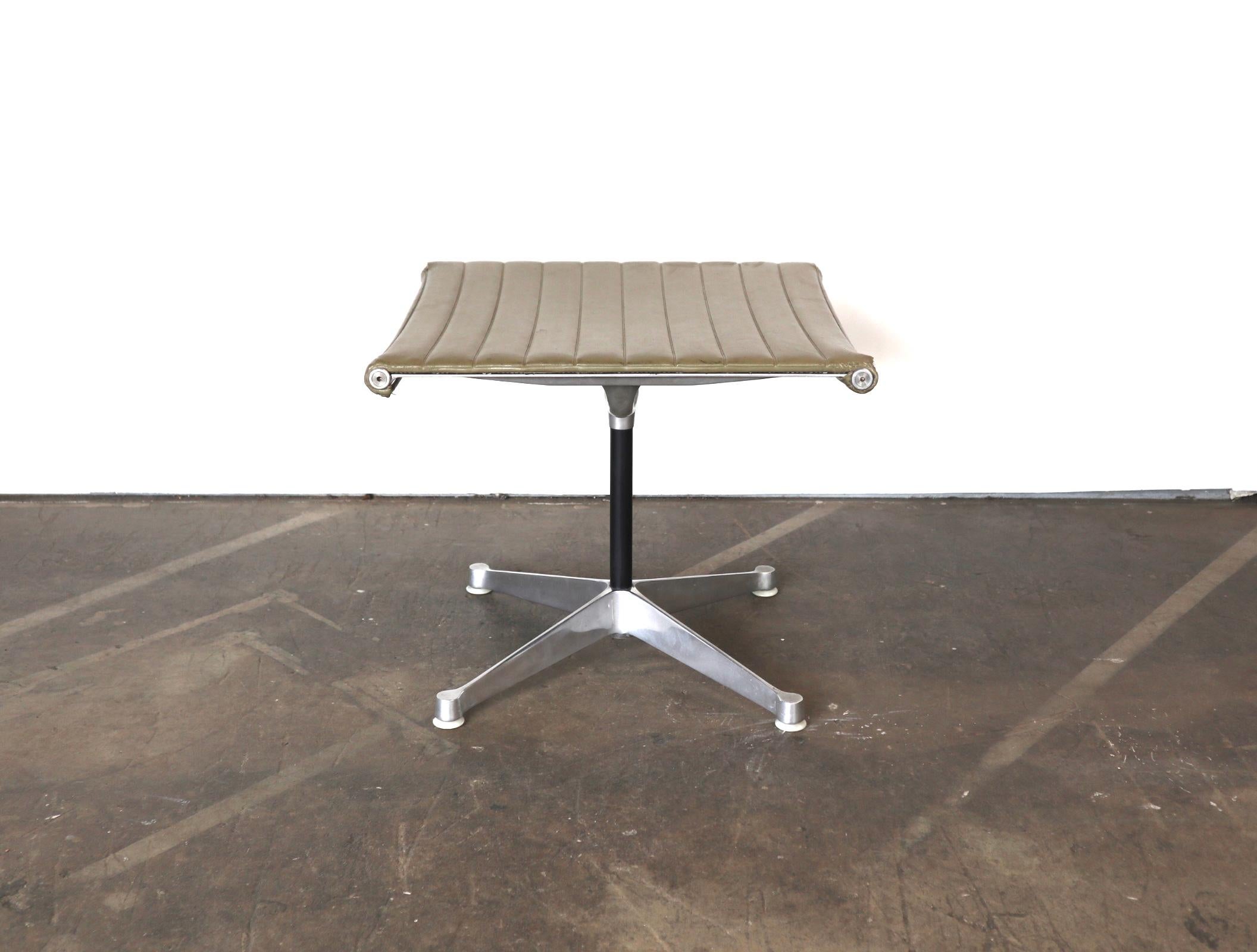 Gorgeous vintage ottoman designed by Charles and Ray Eames for the Herman Miller aluminum group series. Olive naugahyde upholstery in good condition with normal wear. Polished aluminum presents well and the base is stamped Herman Miller. All