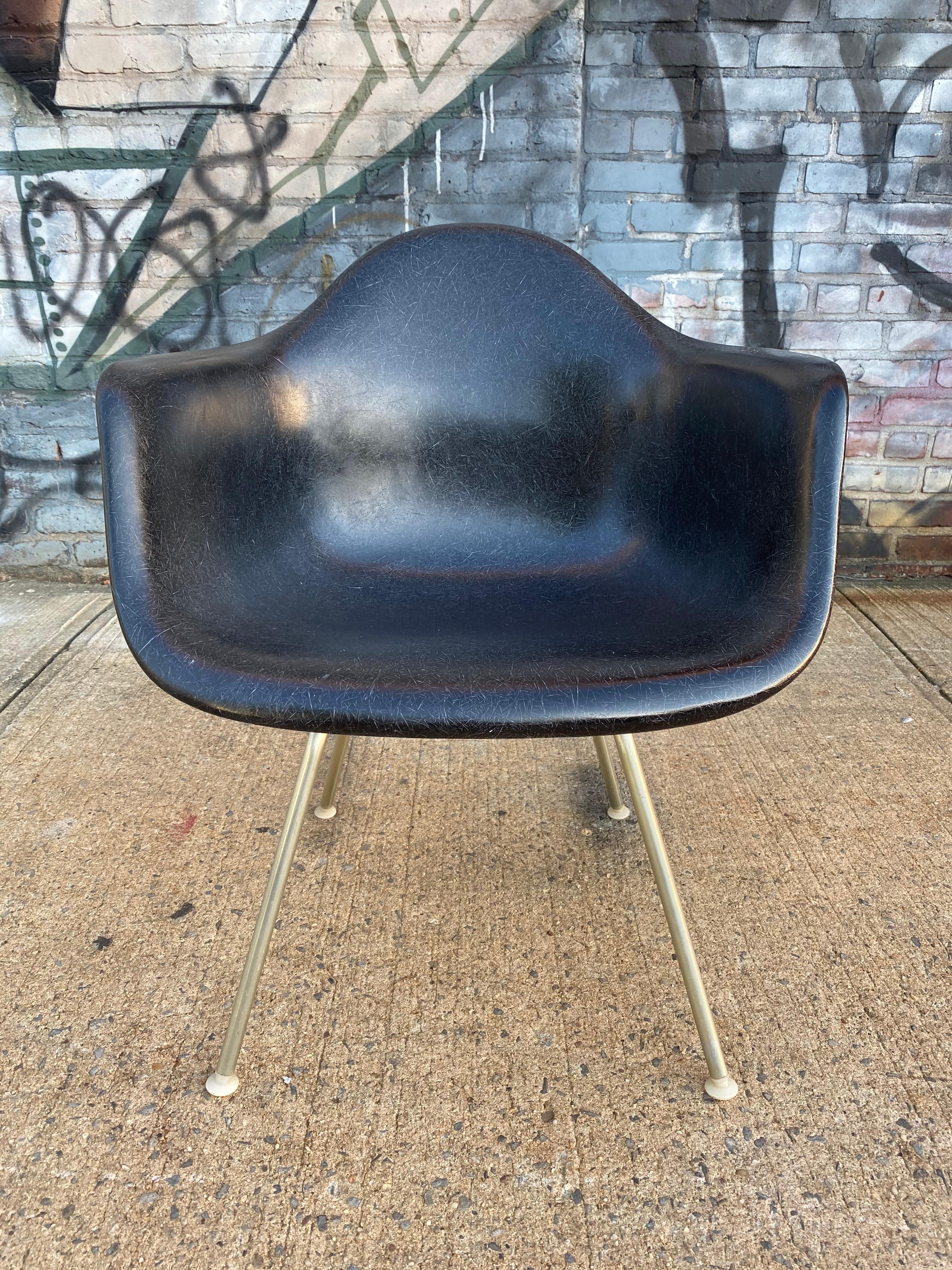 Gorgeous black Herman Miller Eames fiberglass armchair on authentic Herman Miller lounge height base. Base of zinc plated tubular steel. All glides intact and they are self leveling made of nylon. They adjust to and are safe on multiple types of