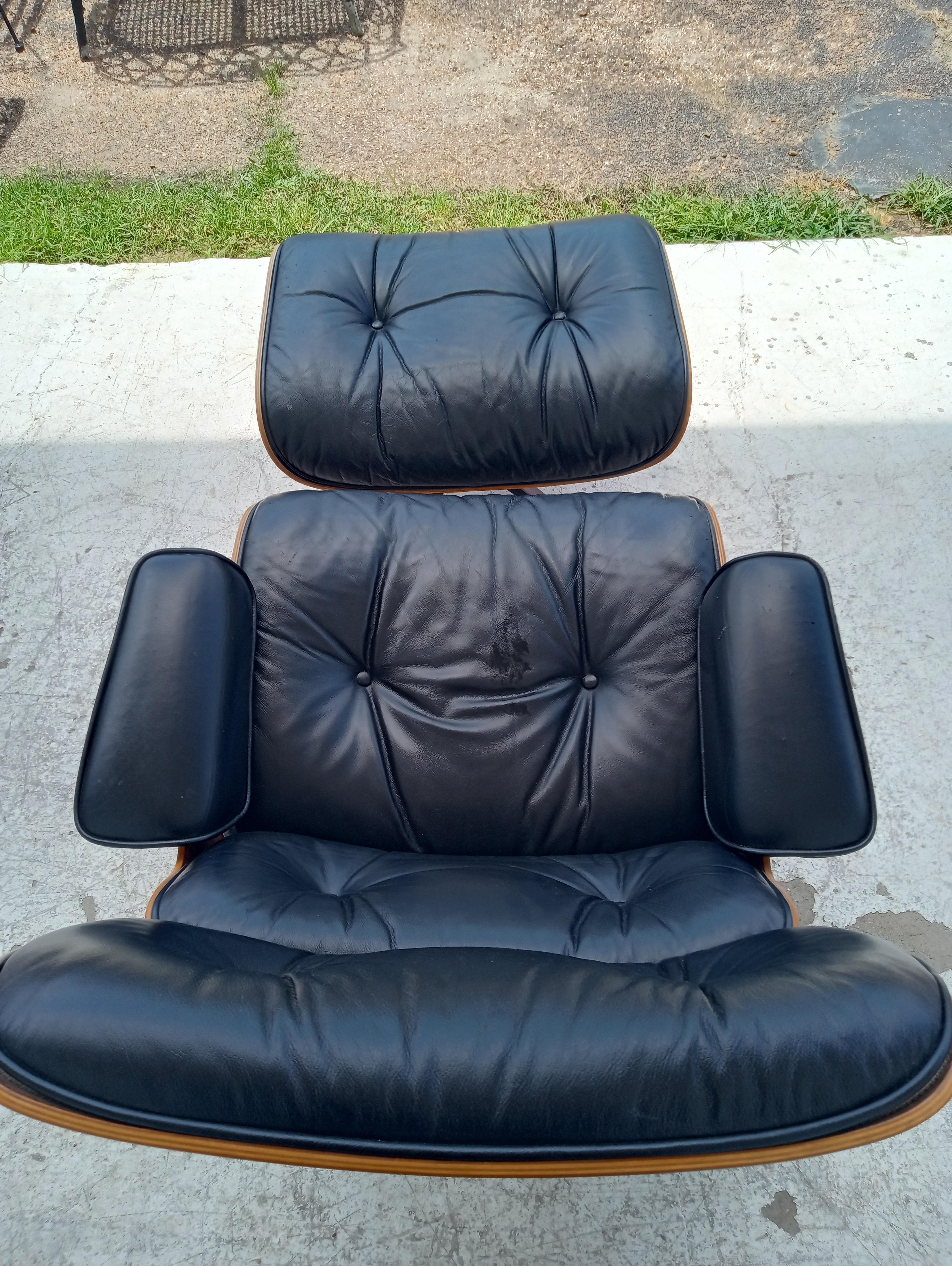 This is the iconic Eames chair by Herman Miller. It was designed by Charles and Ray Eames in 1956 and is still in production today. It has leather upholstery with a rosewood shell. It has a swivel 4 star black aluminum base .
Accompanying it is the