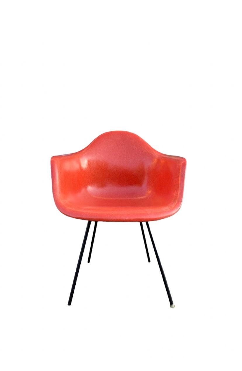 Gorgeous and rare hue of red orange on this vintage fiberglass Herman Miller Eames armchair. Model DAX with H base. All shock mounts intact. Stamped Herman Miller under chair and guaranteed authentic.
