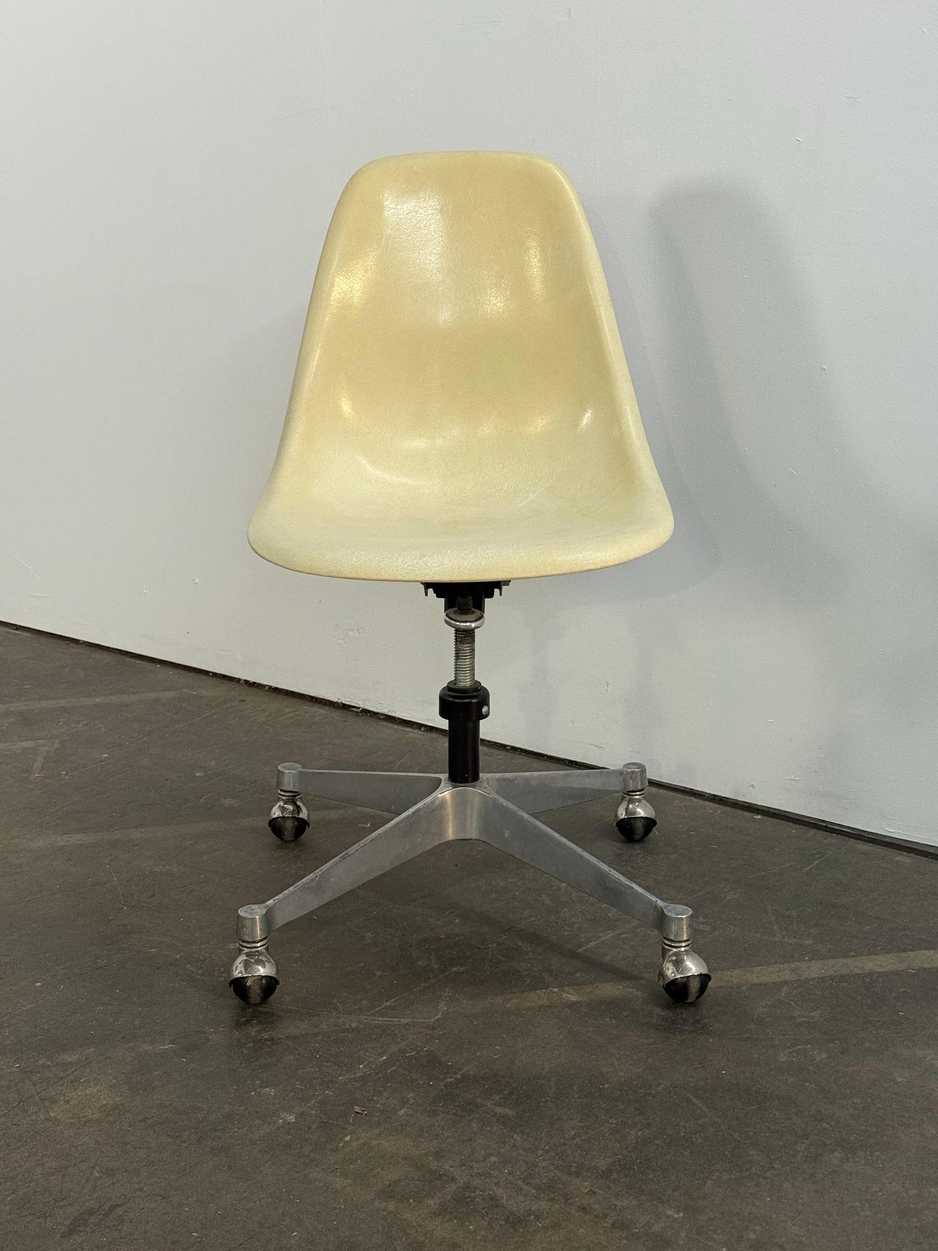 Herman Miller Eames Schreibtischstuhl aus Fiberglas. Pergamentfarbener, kipp- und schwenkbarer Sockel mit verstellbarer Höhe. Der Sockel ist schwenkbar und die Rollen sind funktionstüchtig. Frühe Muschel signiert und garantiert echt.