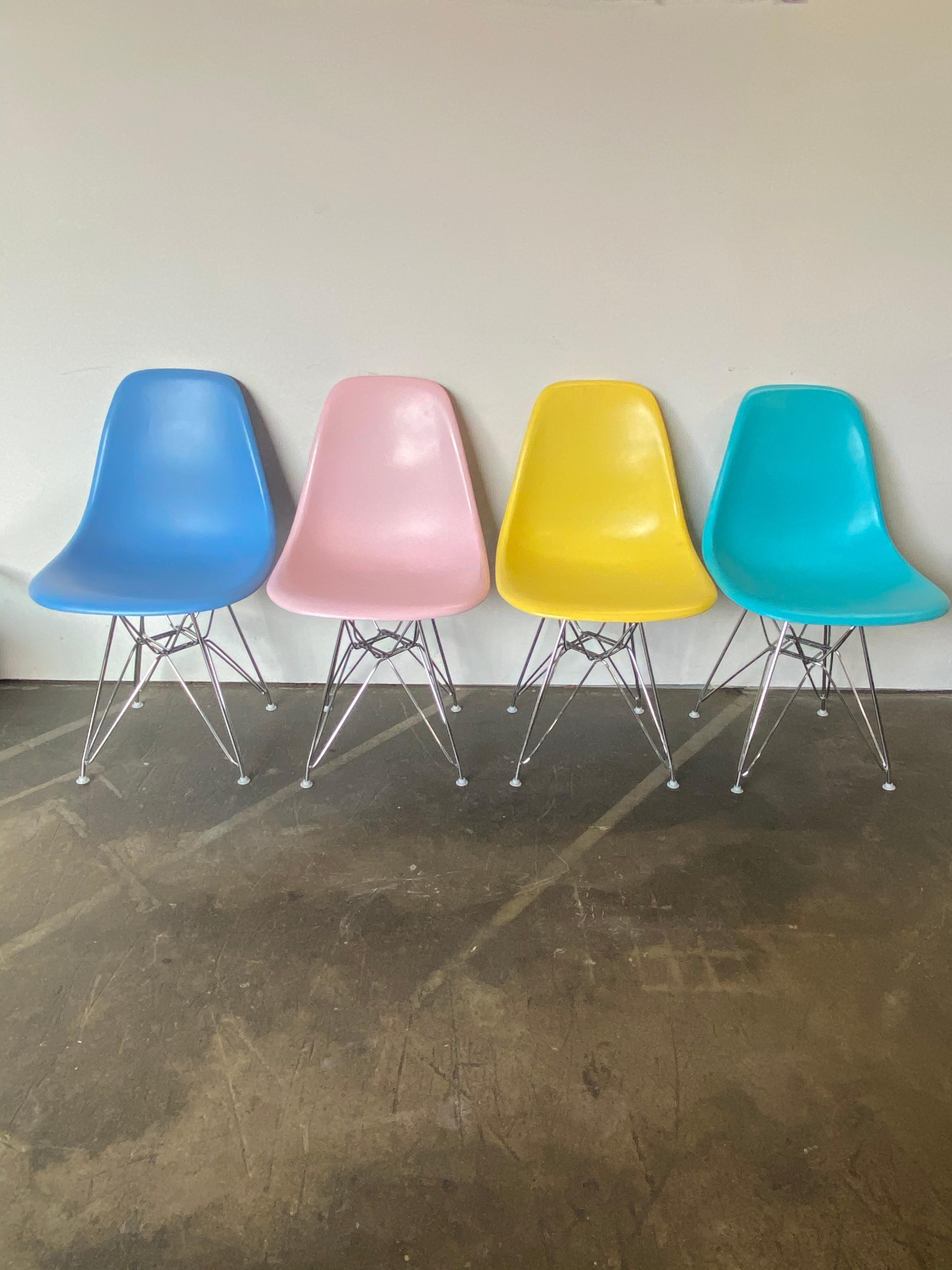 Gorgeous set of 4 Herman Miller Eames dining chairs. Vintage fiberglass shells are stamped Herman Miller and guaranteed authentic. Surfaces has been custom recoated in vibrant colors (which were not originally offered) and clear coated. On new