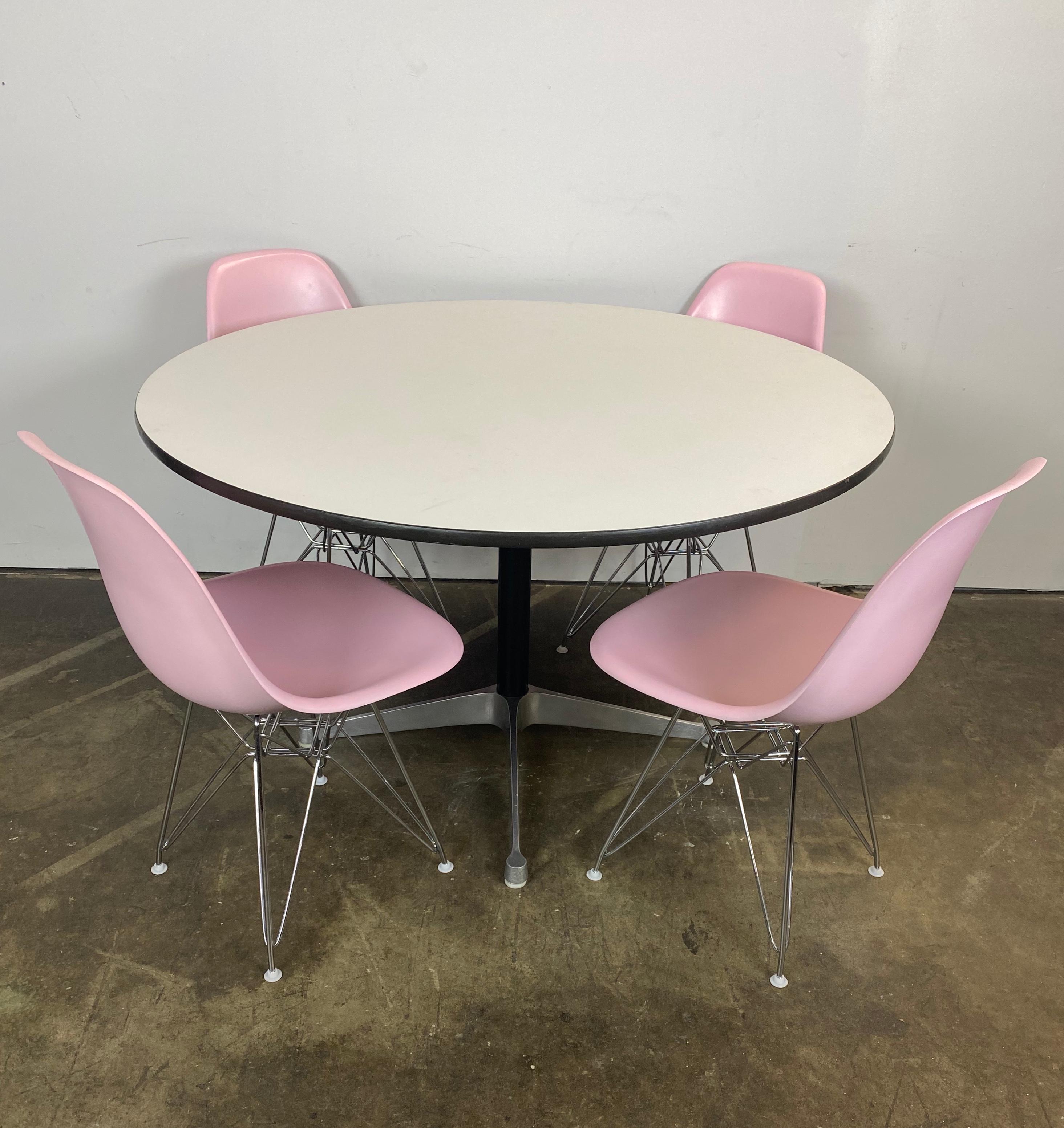Magnifique ensemble de salle à manger Herman Miller Eames. Avec 4 chaises DSR de modèle rose, recouvertes de rose et posées sur de nouveaux piétements Eiffel. Toutes les chaises sont signées Herman Miller et garanties authentiques. Les patins en