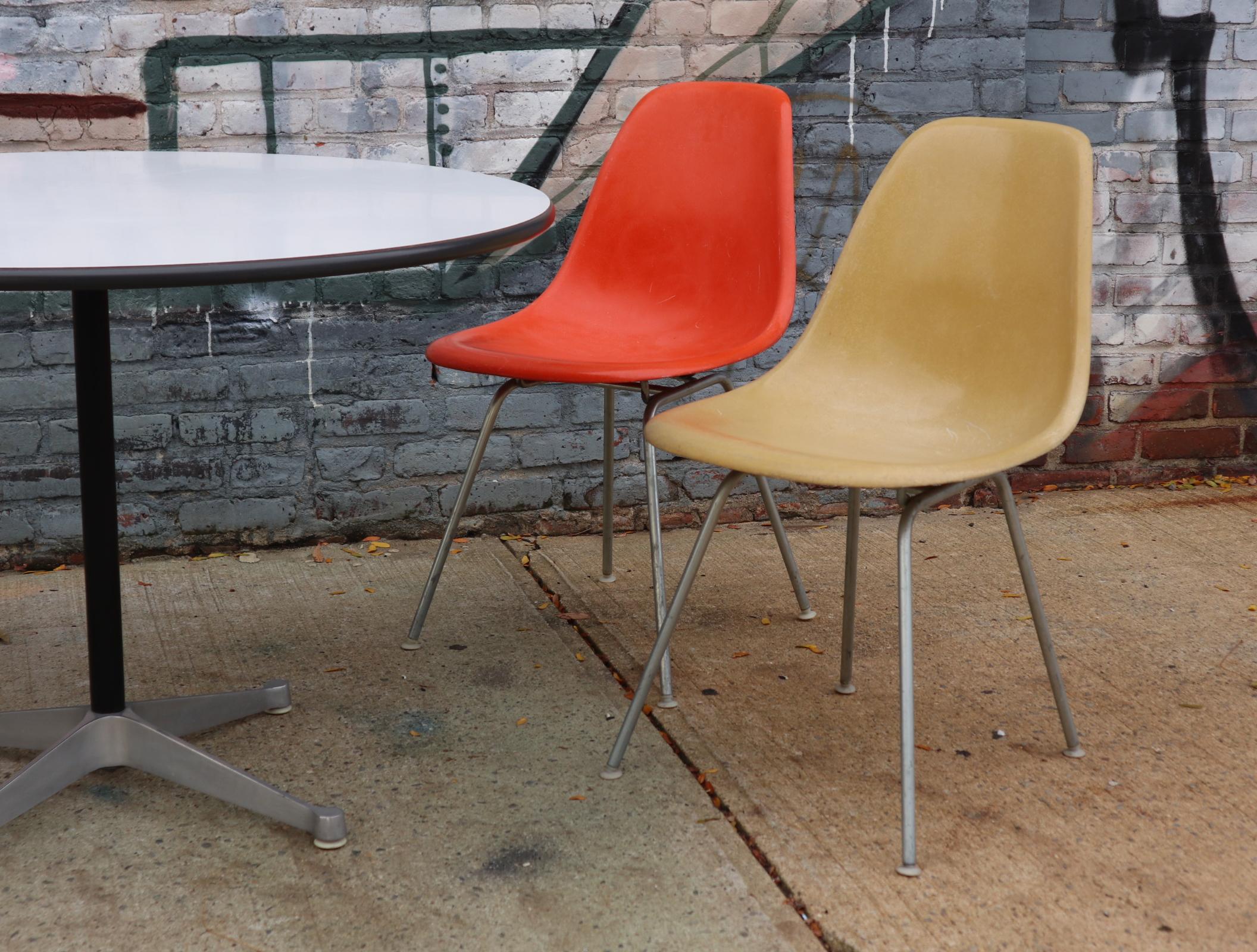 Lovely original Herman Miller Eames dining set. Featuring authentic vintage fiberglass shell chairs in assorted colors and 42 inch diameter dining table. Laminate top in good condition with consistent color. Chairs without cracks or holes. Good