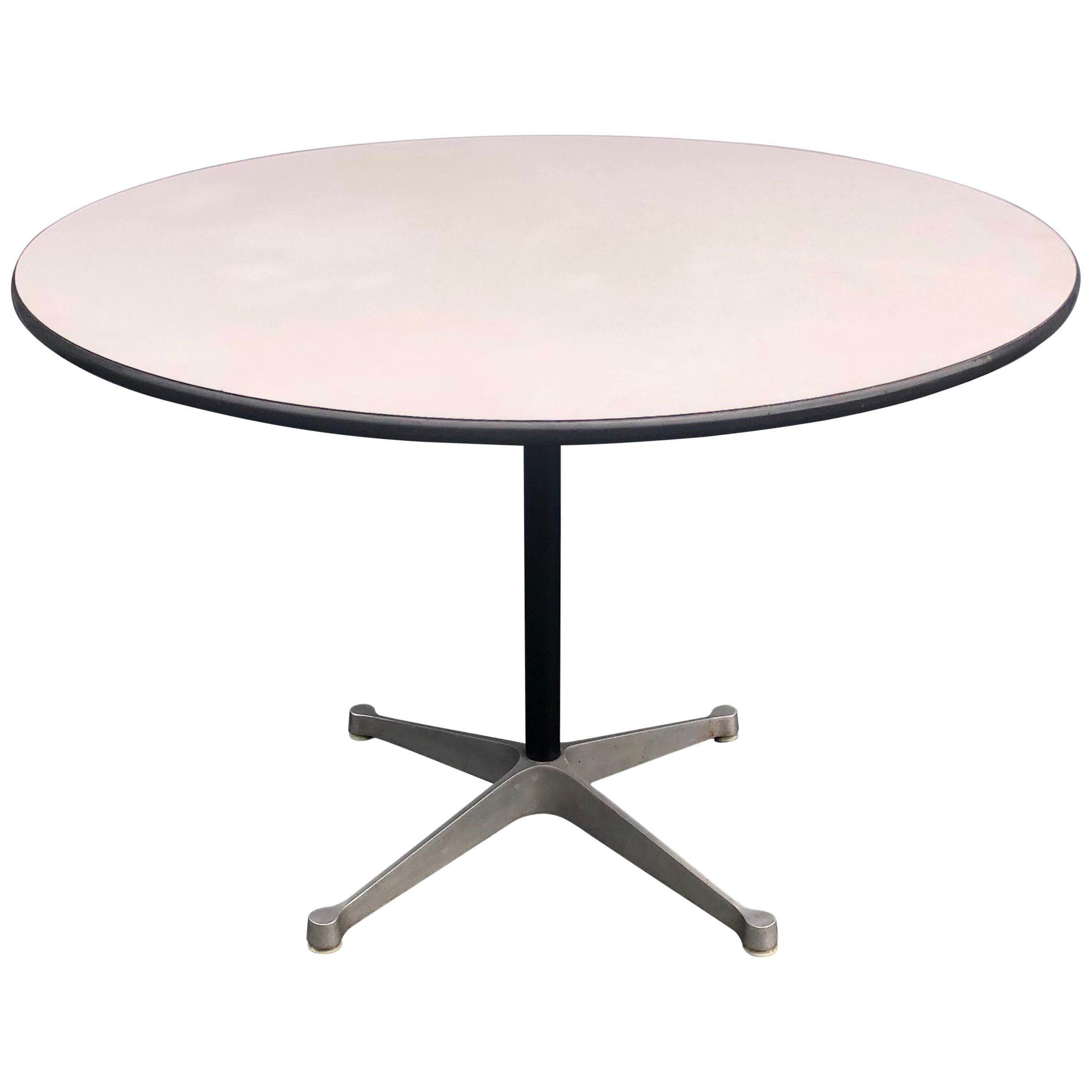 Herman Miller Eames dining table. White laminate top and aluminum base on white pedestal. Signed with Herman Miller tag. From 1950-60s. In good condition with moderate wear. 