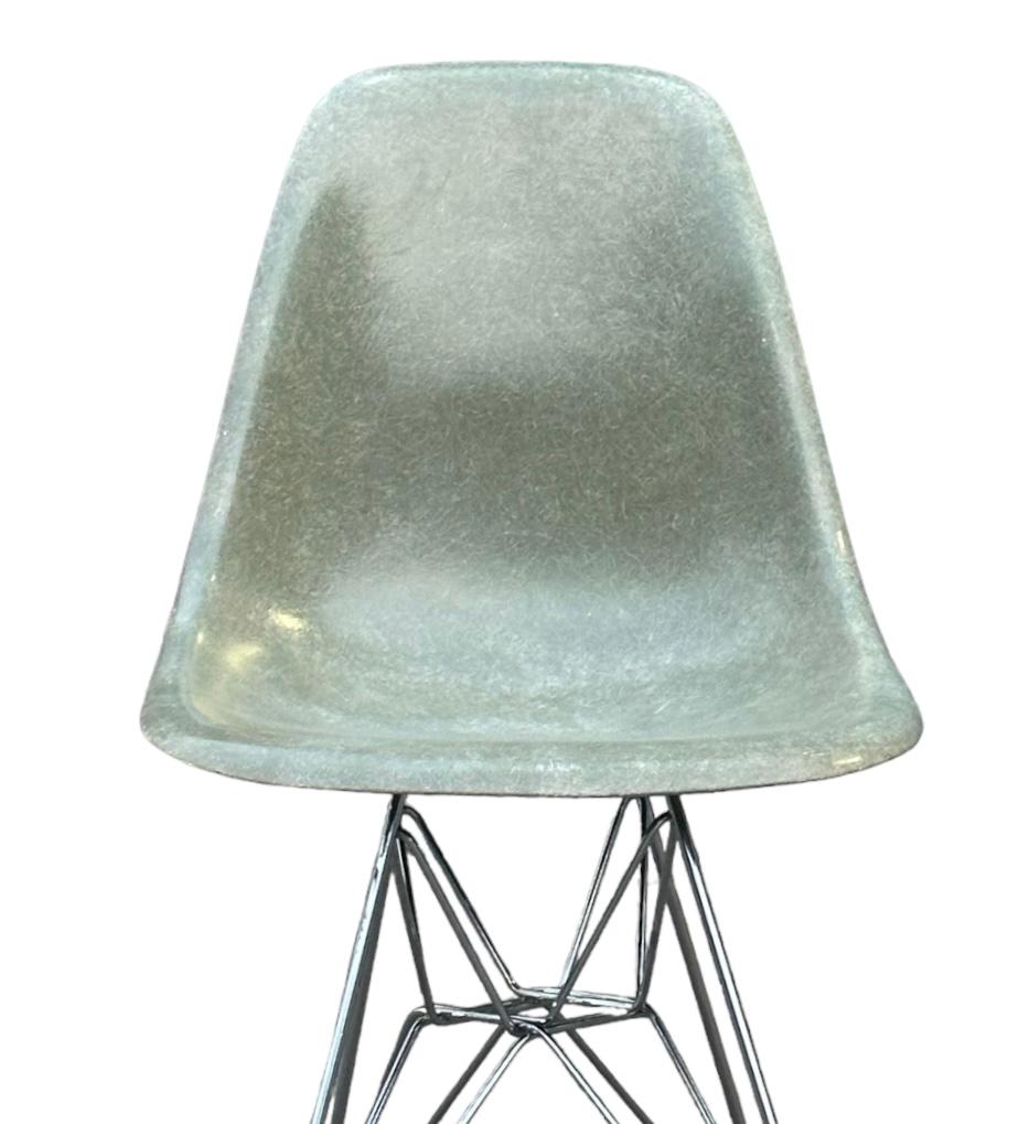 Beautifully aged Eames fiberglass dining chair (model DSR) in Seafoam Green. Original Herman Miller production shell. Chrome rod wire “Eiffel” base with all glides and screws intact. No damage to the shell. Structurally sound and guaranteed