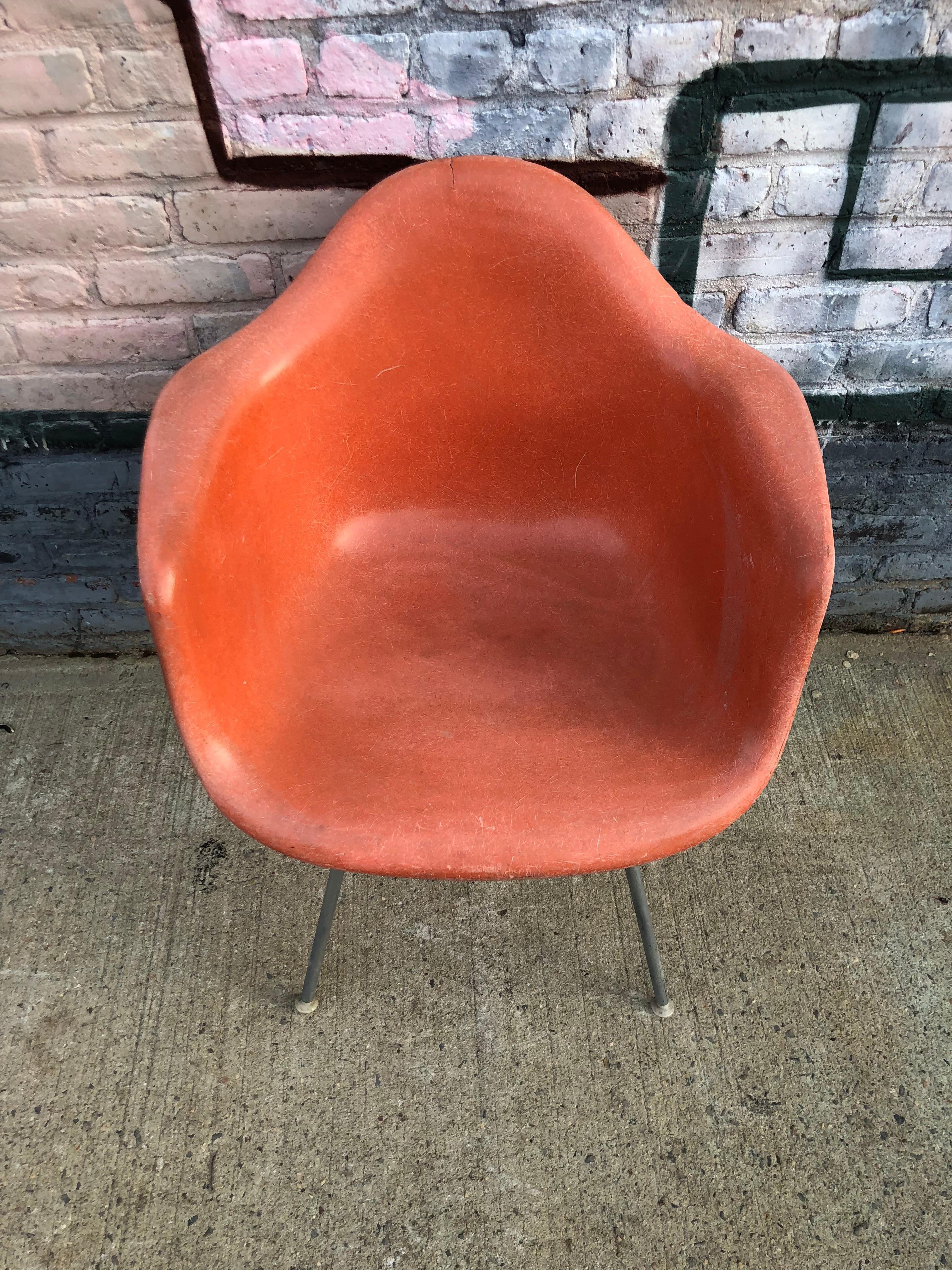 Vintage Herman Miller Eames fiberglass armchair in red orange. Embossed Herman Miller on authentic base. All mount and glides intact, circa 1960s.