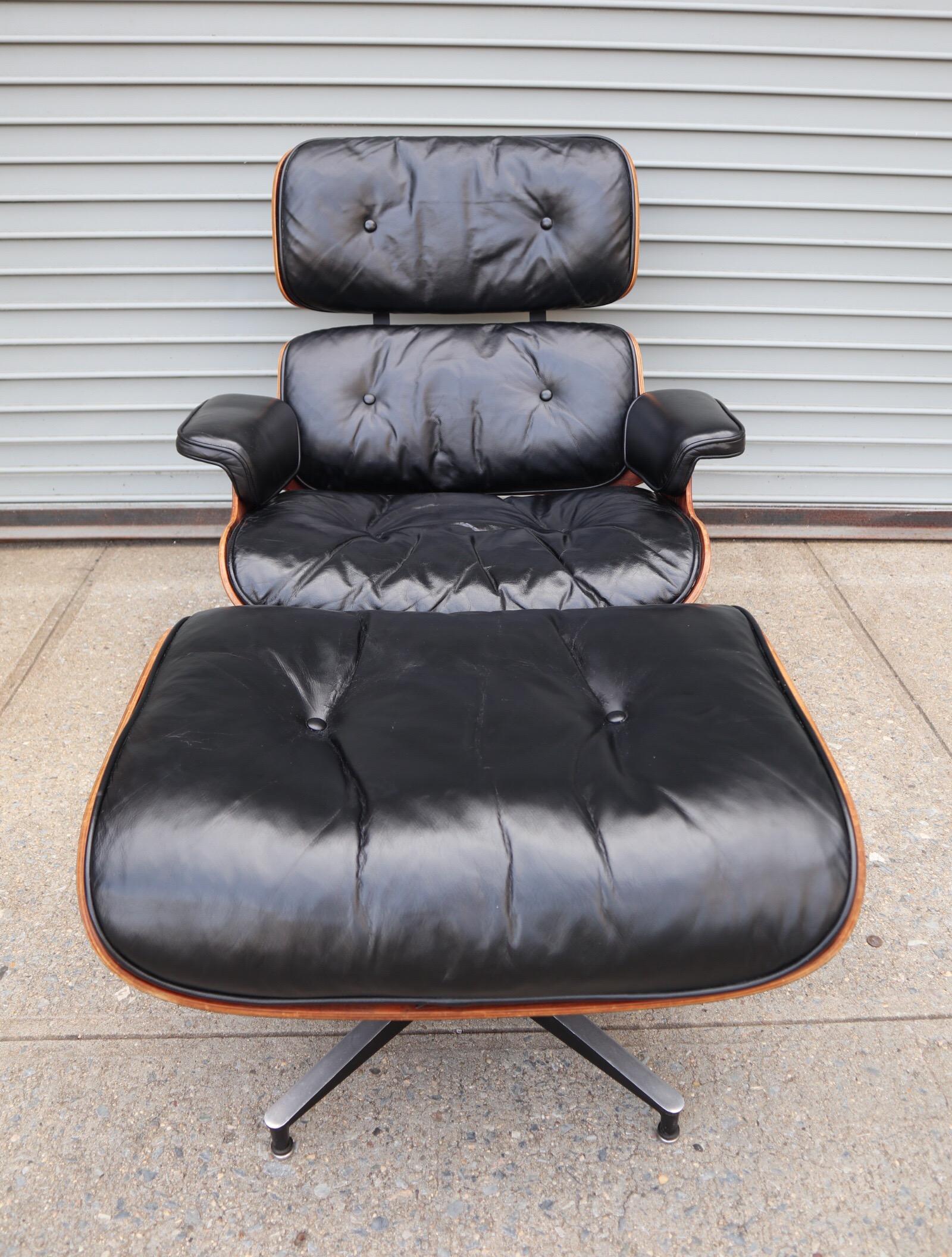 Gorgeous example of the Classic Eames lounge and ottoman. Lovely deep reddish rosewood grains with notable grain pattern and texture. Original chair and ottoman. Black leather cushions in good condition. Chair swivels smoothly. Bases retain all