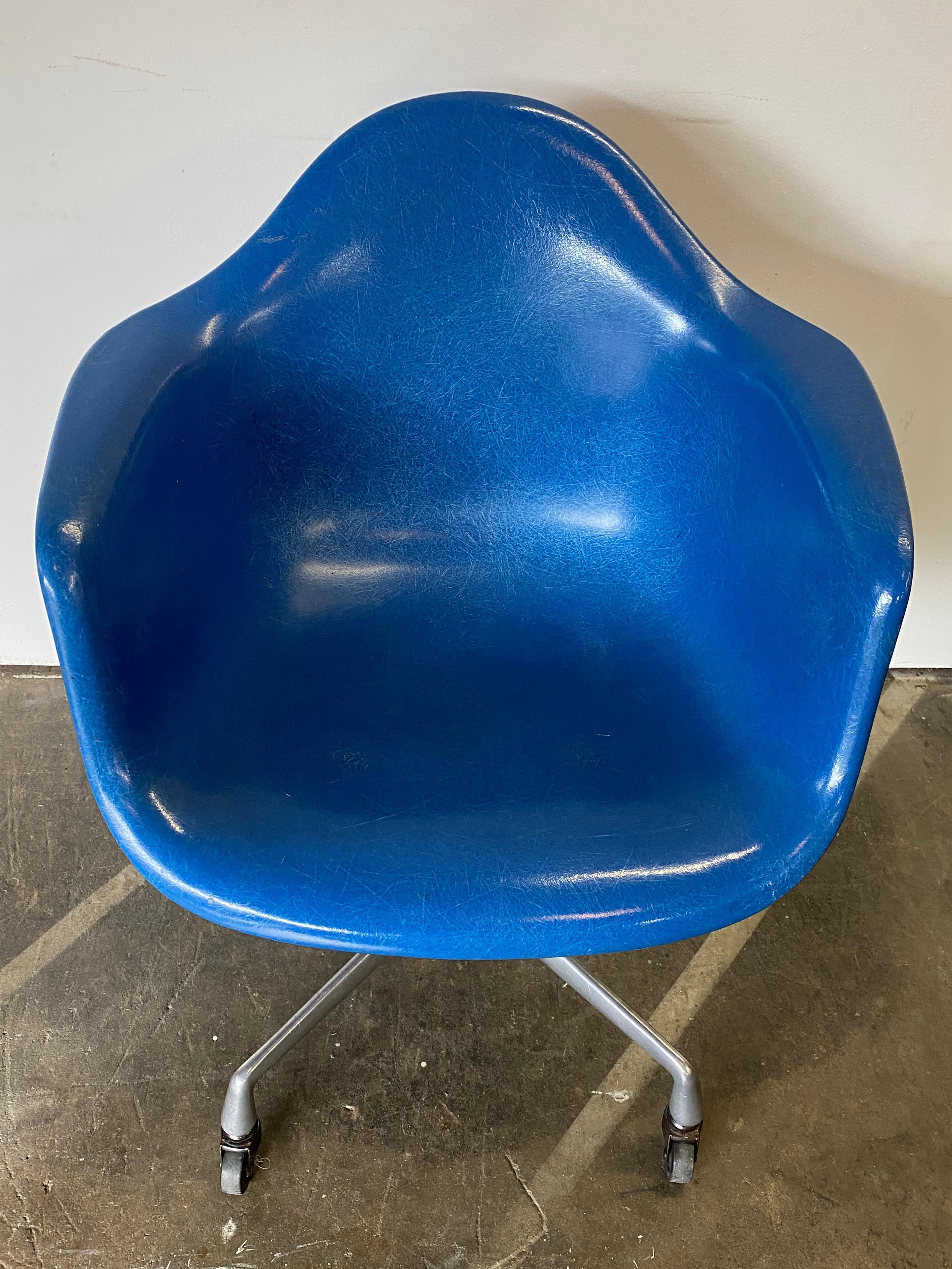 One of the most sought after colors in Eames shell chairs: Ultramarine blue. This chair has bright bold color with no sun fading. Signed Herman Miller and guaranteed authentic. Sits atop rare Herman Miller aluminum desk base. Swivels and rolls