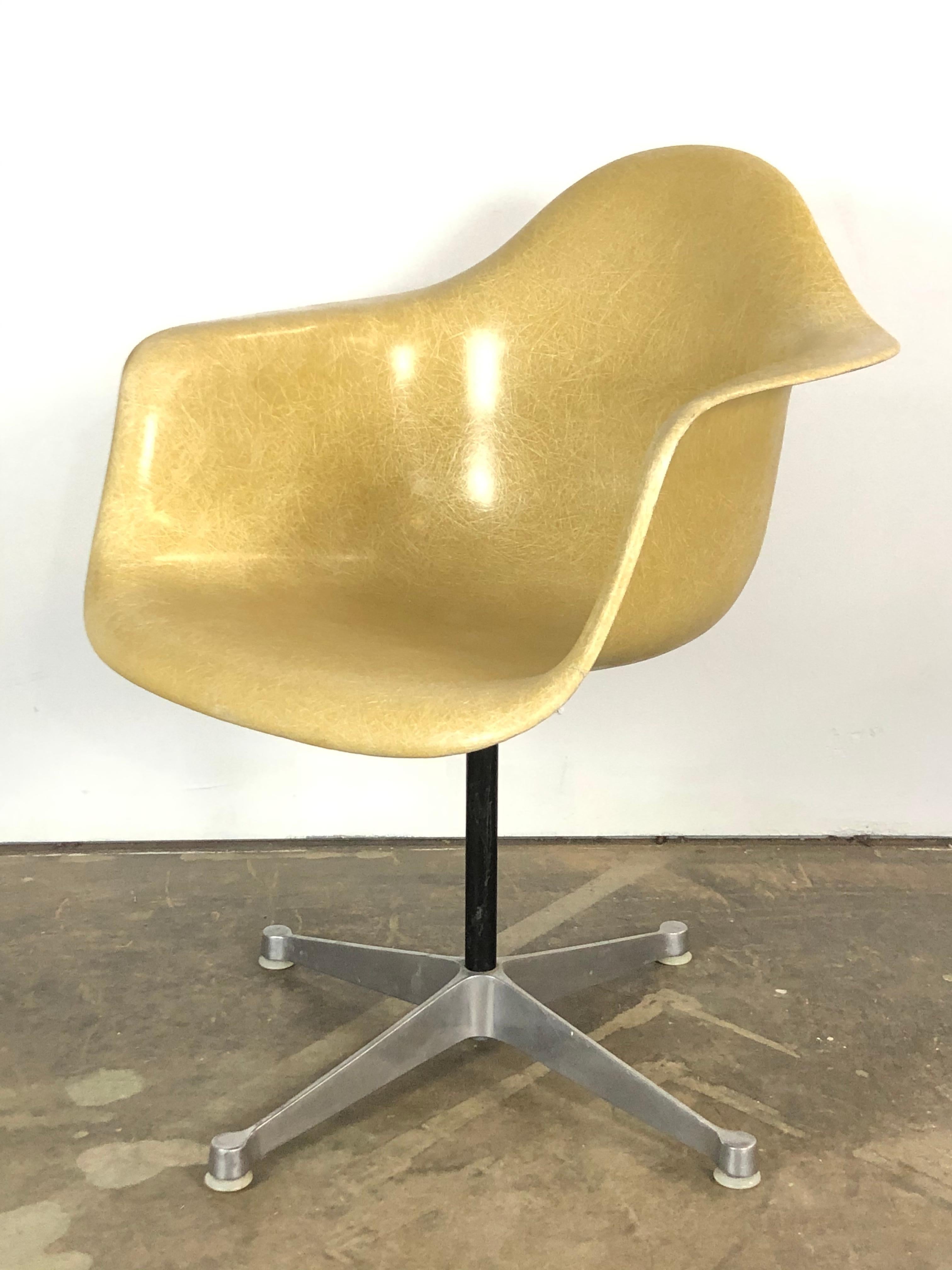 Classic example of the iconic Eames fiberglass armchair. Model PSC in Ochre light. Aluminum base swivels smoothly and retains all 4 nylon floor glides for use on multiple surfaces. In good condition with expected wear from age and use.