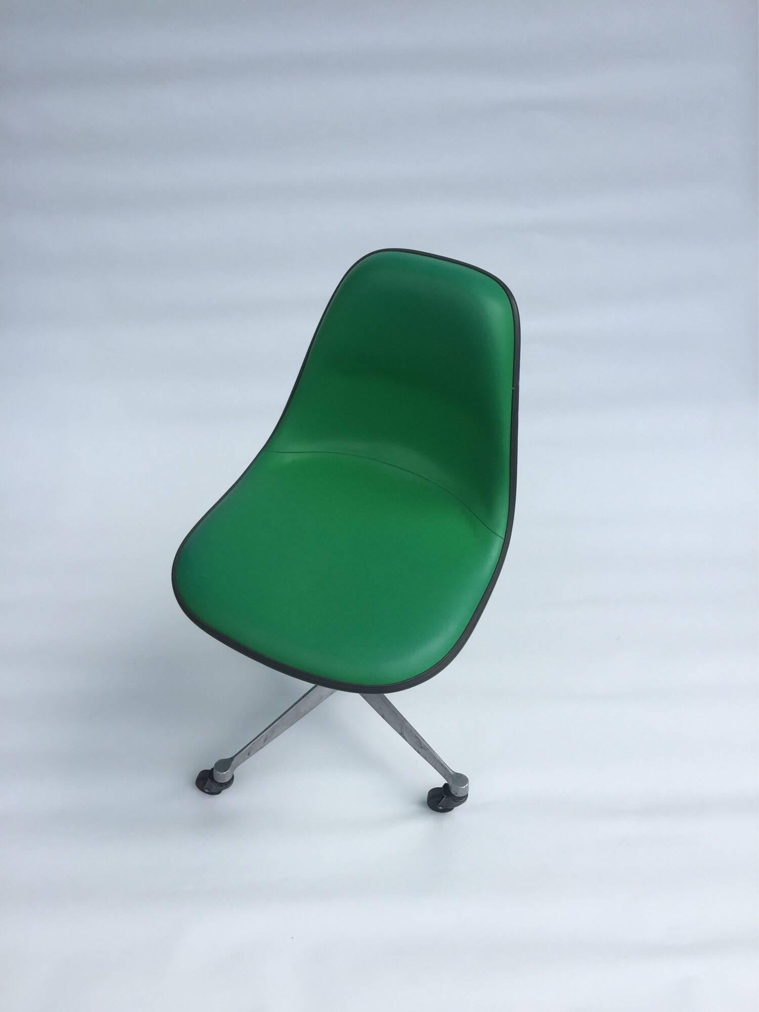 Kelly green fiberglass and vinyl Eames shell chair with rare back padded support on four point rolling office base. similar to the PSCC chair. Chair is in good condition and the Kelly green color is vibrant and bright.