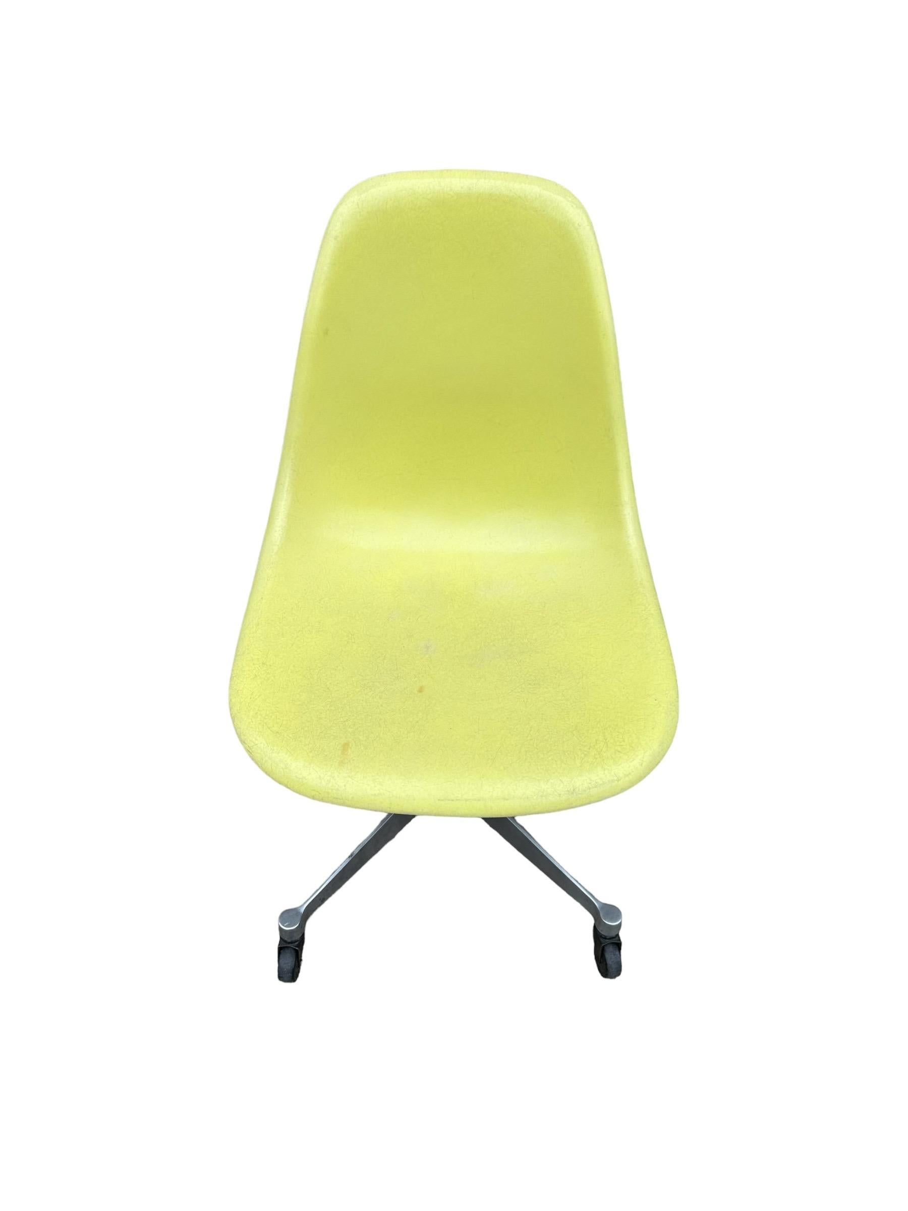 Light yellow fiberglass shell desk chair by Herman Miller. Designed by Charles and Ray Eames. Model PSCC, with swivel base and casters. In good working condition. No holes or cracks, all parts intact. Signed and guaranteed authentic. Comfortable