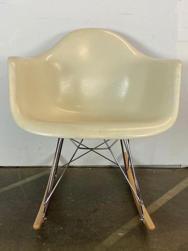 Gorgeous edition of the design classics model RAR rocking chair by Charles and Ray Eames and manufactured by Herman Miller. Clean parchment shell with even color and no cracks or holes. Signed Herman Miller and guaranteed authentic. New base in