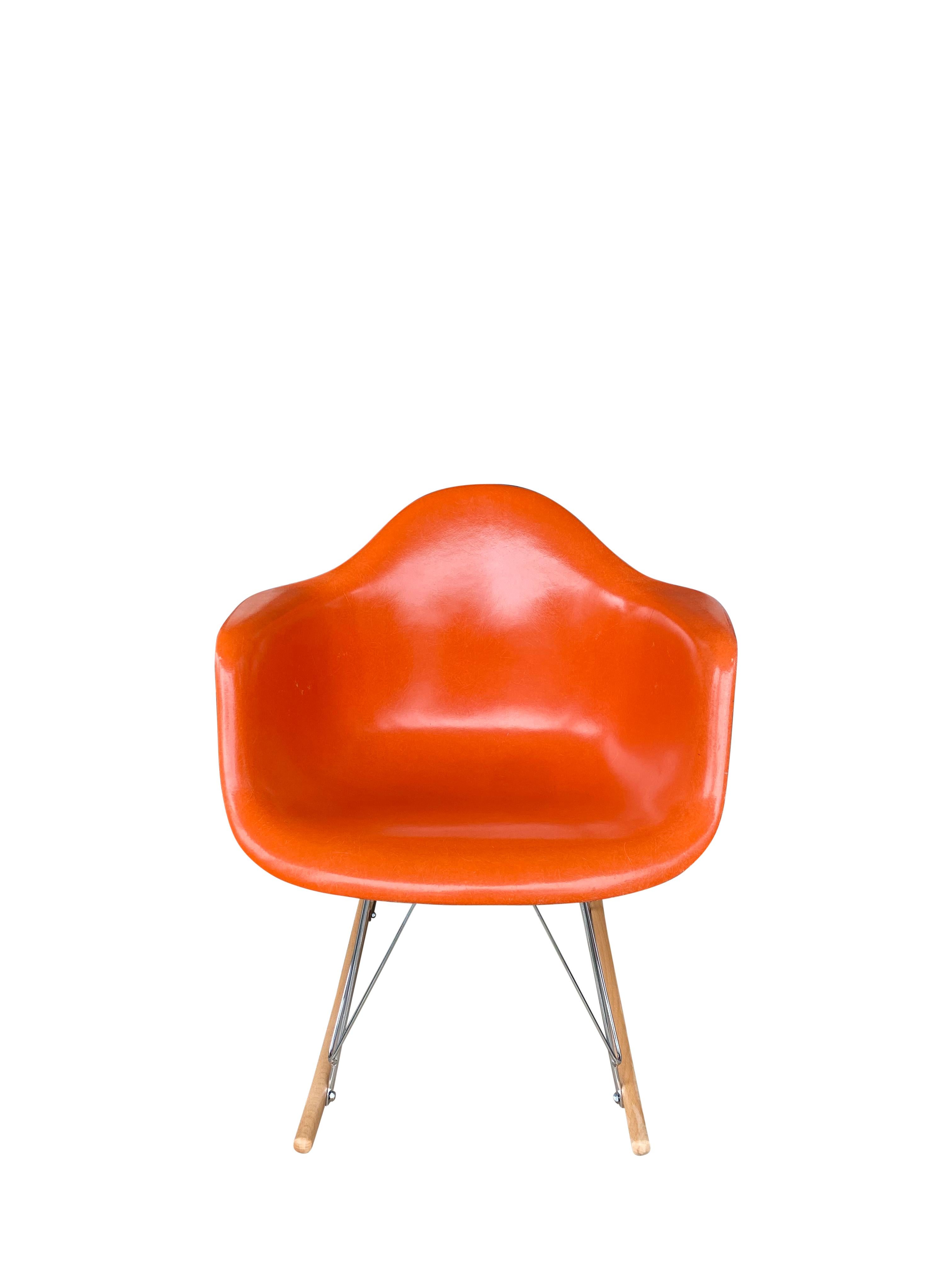 Gorgeous edition of the design classics model RAR rocking chair by Charles and Ray Eames and manufactured by Herman Miller. Clean shell with gorgeous and vibrant red orange hue and no cracks or holes. Signed Herman Miller and guaranteed authentic.