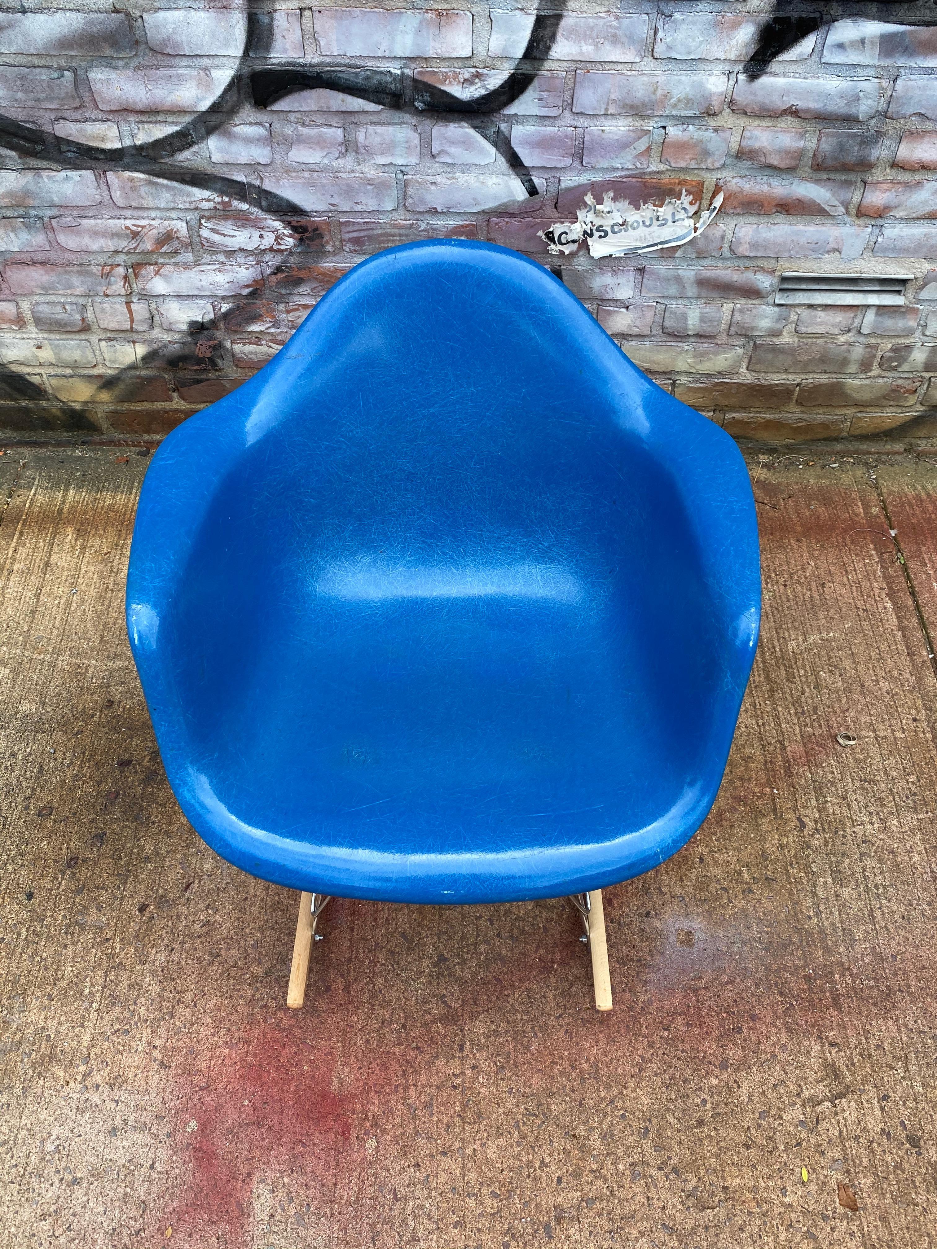 Bright blue example of the classic Eames rocker. The shell is signed and embossed Herman Miller and guaranteed authentic. Very rare color shell on new base with light wood runners on metal base.