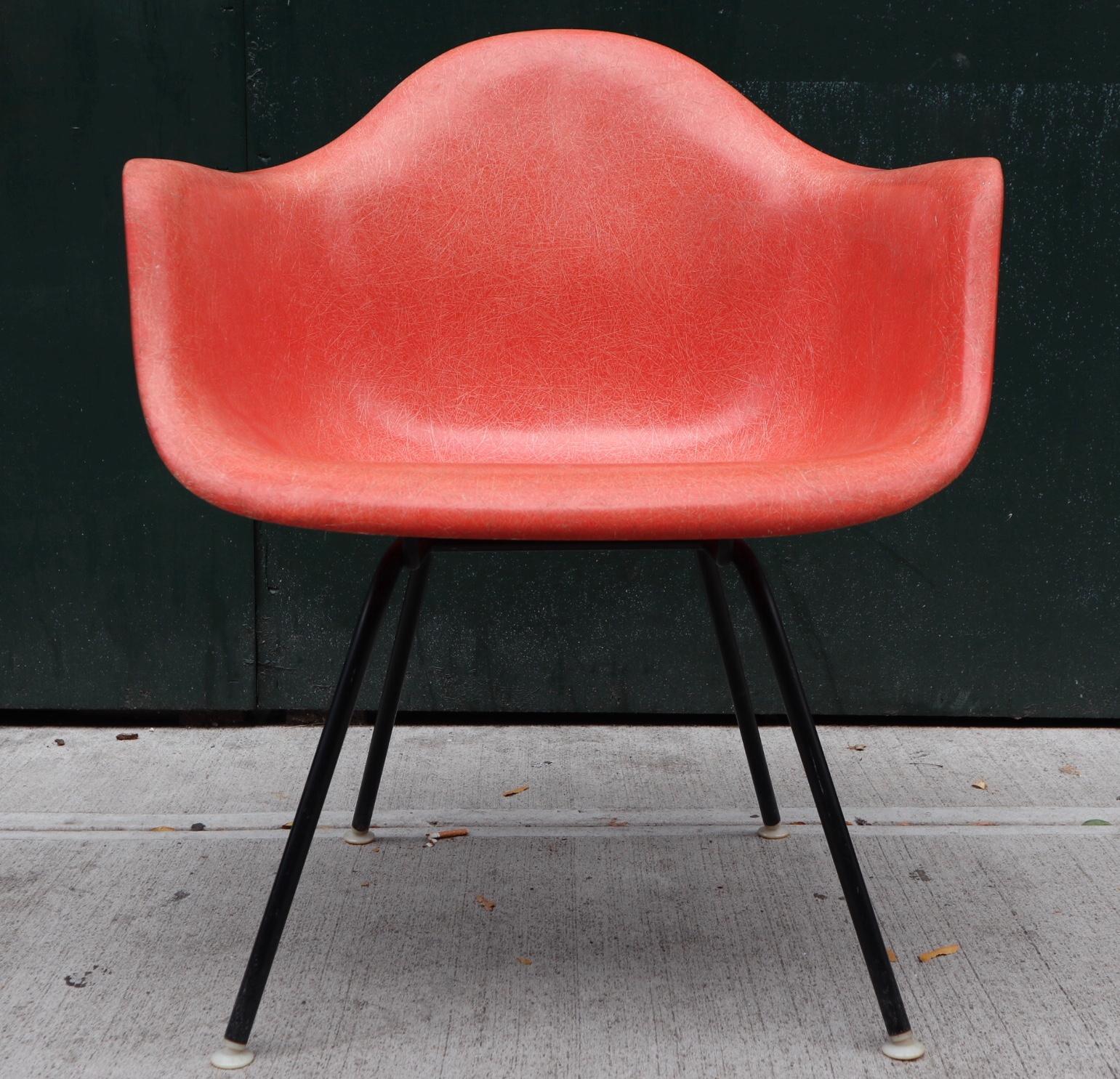 Amazing color on this Eames fiberglass armshell for Herman Miller. Beautiful coral tone contrasts nicely against black lounge height base. No cracks or major wear. Even color throughout. Signed with Herman Miller label underneath the shell. All