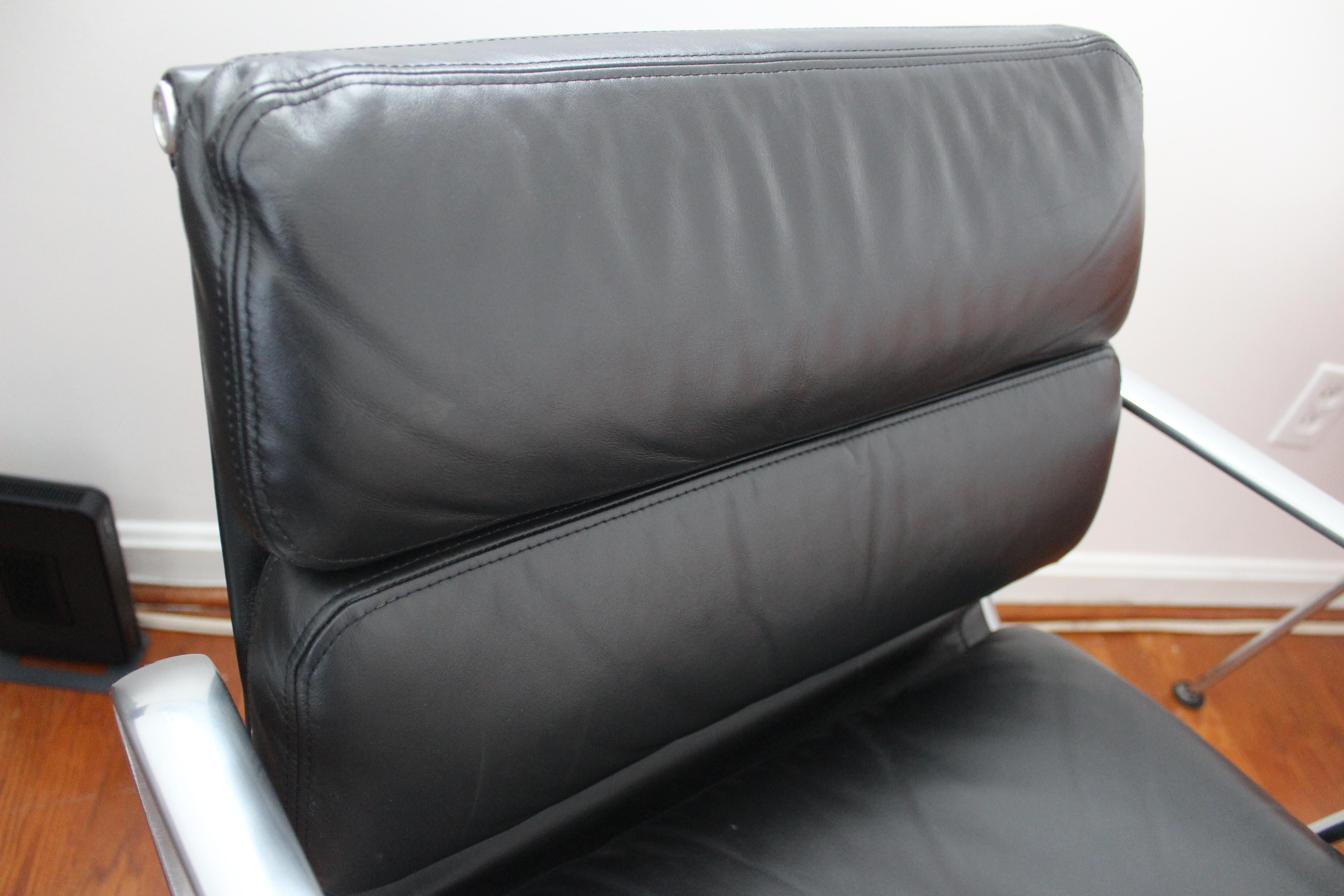 Classic vintage Eames Soft Pad Management Chair with wheels. Height is adjustable. Black leather and aluminum. Original tag on underside.