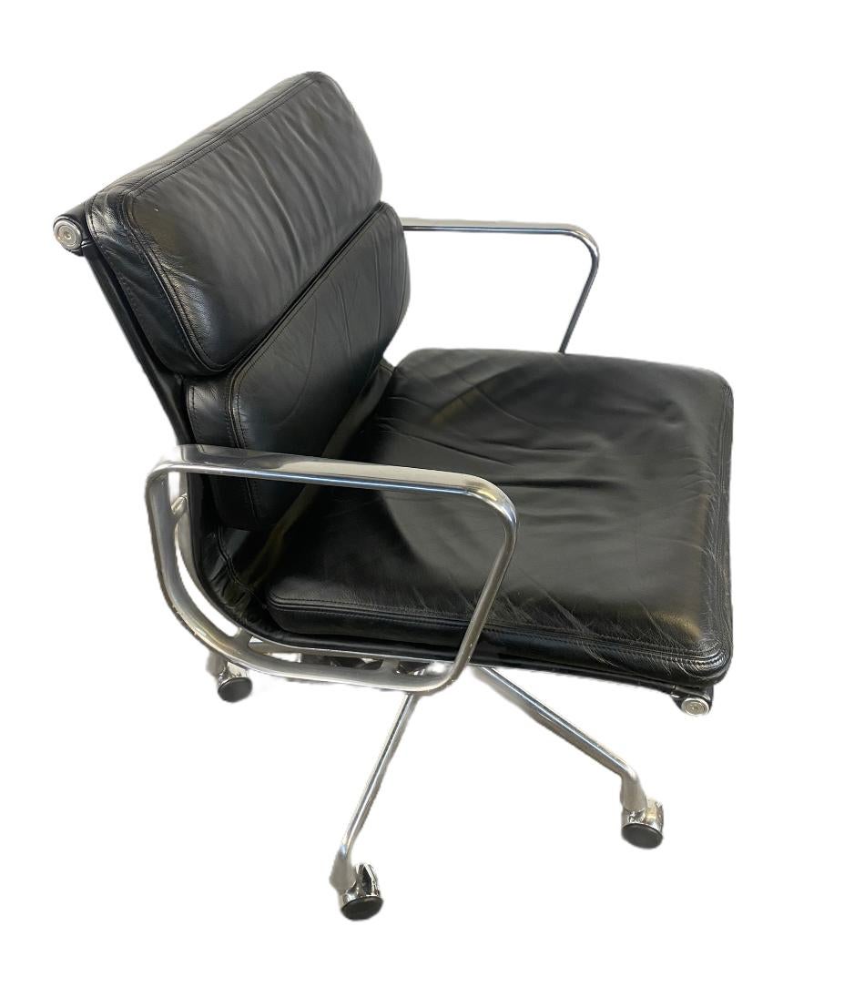 Handsome example of the classic Eames soft pad management desk chair. Extremely comfortable padding wrapped in leather across polished aluminum frame. Chair swivels, rolls, and tilts. Height and tilting tension both easily adjustable. As pleasing to