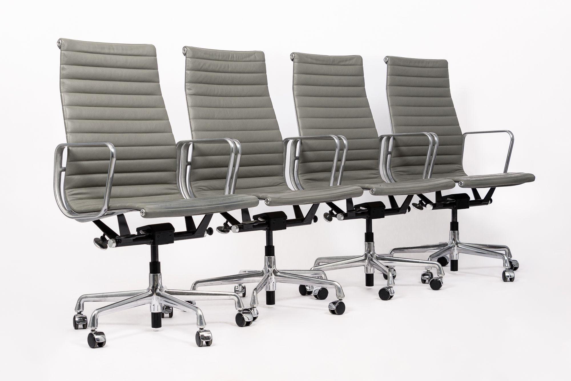 These authentic Eames for Herman Miller Thin Pad Executive Height office chairs from the Aluminum Group Collection were manufactured in 2015. This executive height chair features a taller backrest, gray leather upholstery, polished aluminum