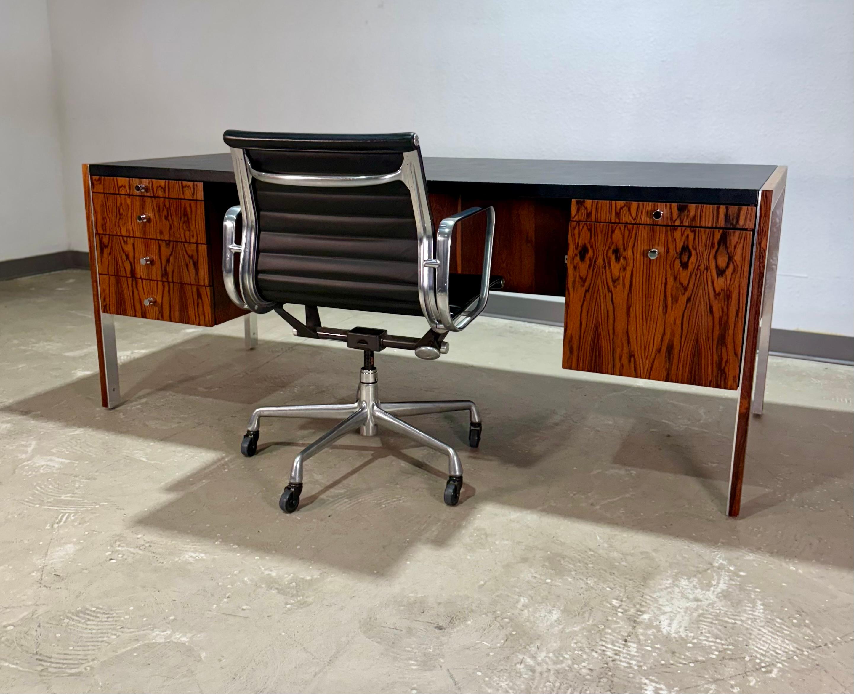 Scrivania direzionale di metà secolo in legno di palissandro, pelle e alluminio attribuita a Herman Miller per Biltrite Canada nel 1968. Un pezzo eccezionale con impiallacciature in palissandro abbinate al libro in tutta la cassa, piano in pelle