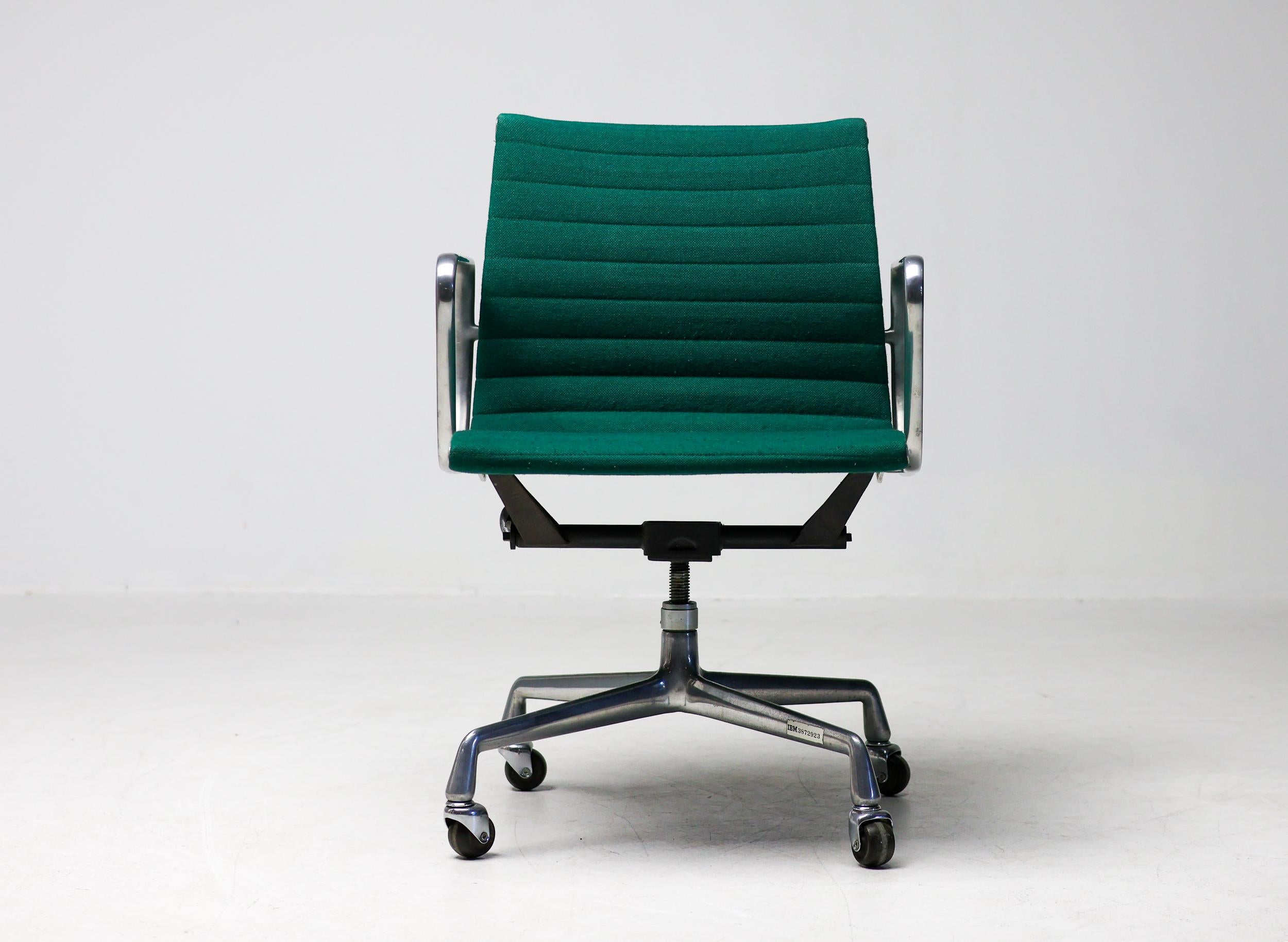 Executive office chair, model EA117, in the USA known as EA335, designed by Charles and Ray Eames for Herman Miller. Backrest and seat in green Hopsak fabric. 
Frame, armrests and early four-star base in die-cast aluminium. Seat mechanism with