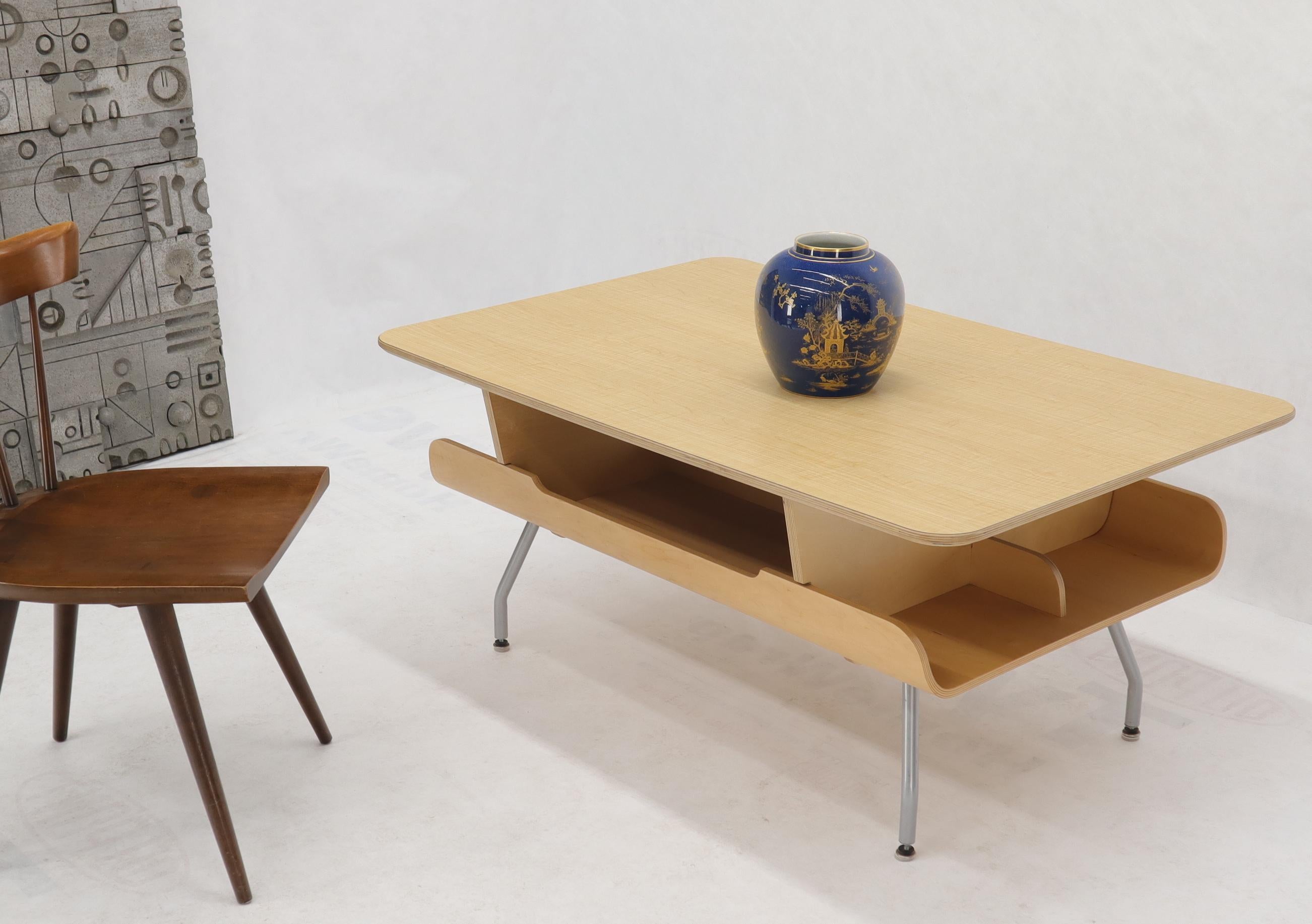 Mid-Century Modern Herman Miller molded plywood bent tube legs coffee table with substantial magazine rack bookcase by Herman Miller.