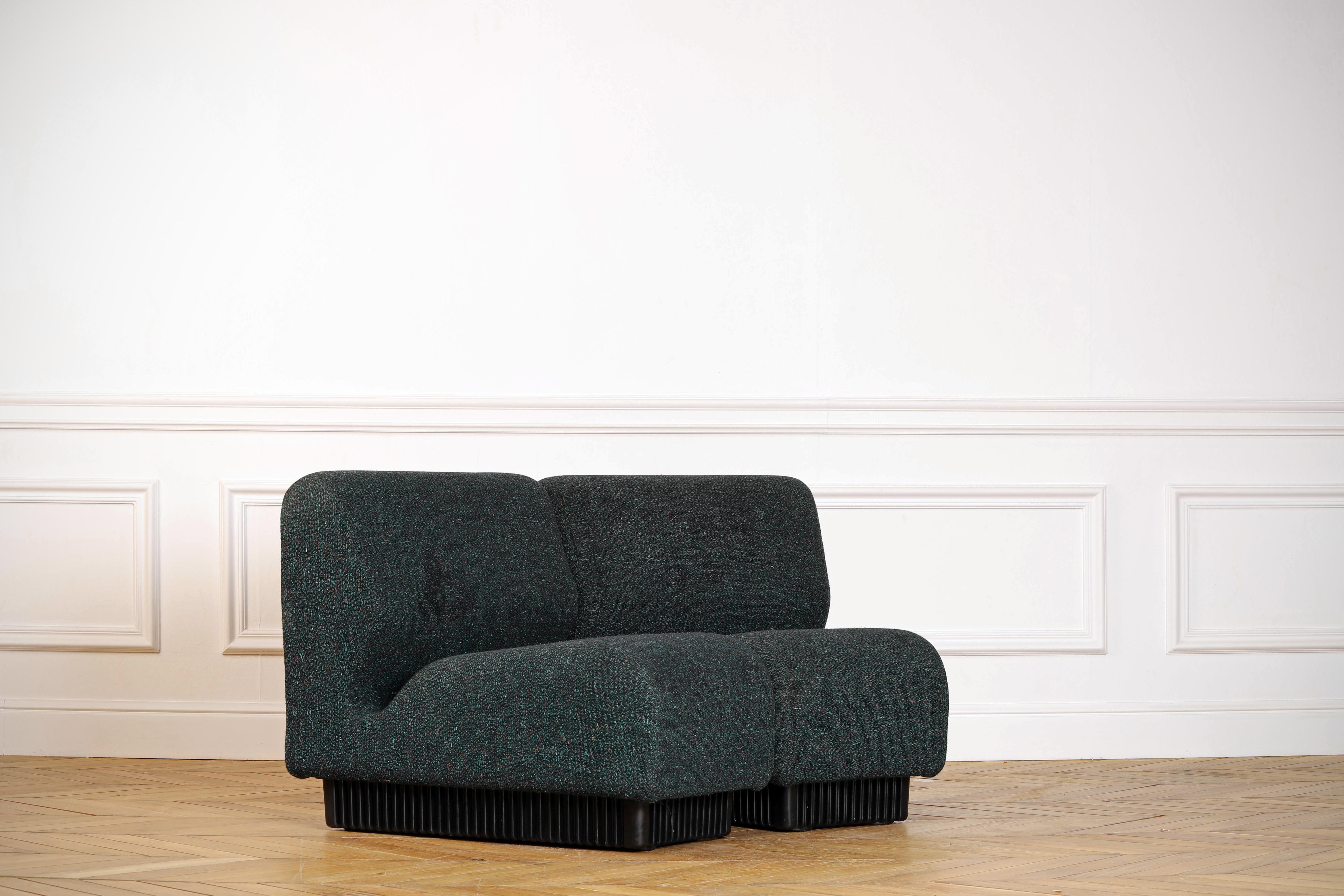 A Mid-Century Modern two-piece modular sofa designed by Don Chadwick for Herman Miller. The sections can be arranged in different configurations. This set is made with green wool and rests on a black molded base.