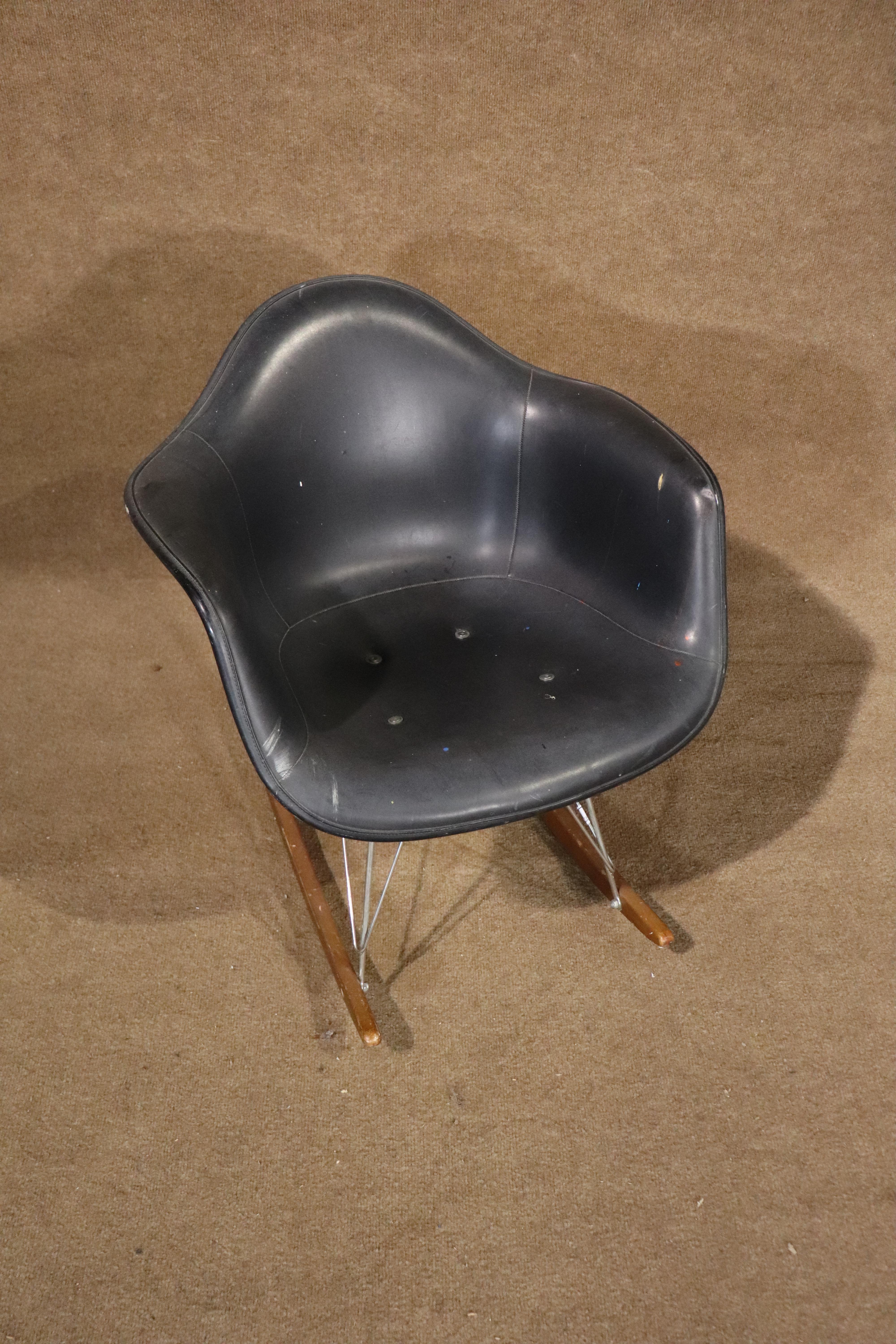 Fauteuil à bascule à coquille emblématique de la modernité du milieu du siècle, conçu par Charles et Ray Eames pour la société Herman Miller, et utilisé par l'université CUNY. Le revêtement en cuir est intact sur la carrosserie en fibre de verre.