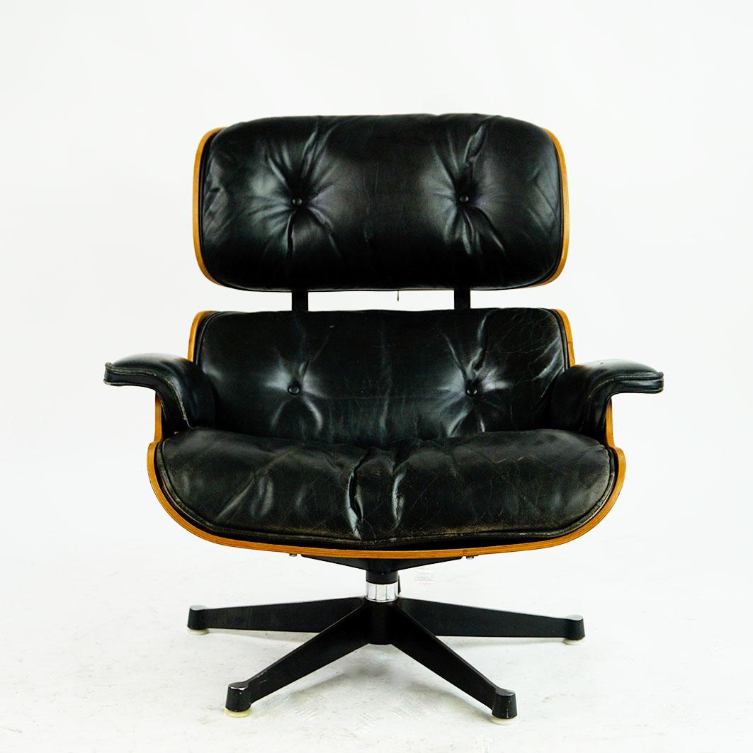 Iconic Herman Miller rosewood lounge chair Mod No 670 with matching stool Mod. no 671, designed 1956 by Ray and Charles Eames, produced circa 1970s. All wood parts have been slightly restored, the chair still has its original very nice patinated