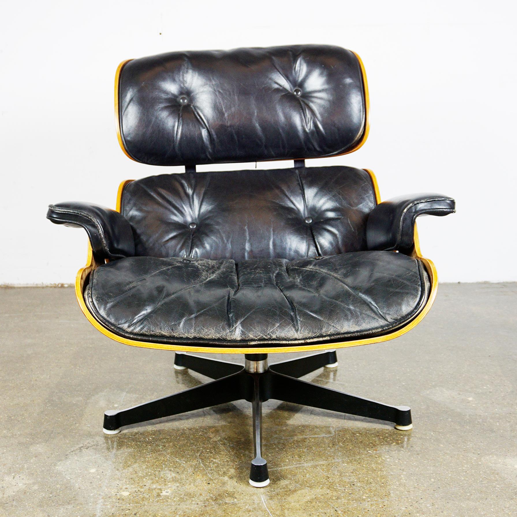 Iconic Herman Miller rosewood lounge chair Mod No 670 designed 1956 by Ray and Charles Eames, produced circa 1960s. All wood parts have been slightly restored, the chair still has its original very nice patinated black leather with some slight wear,