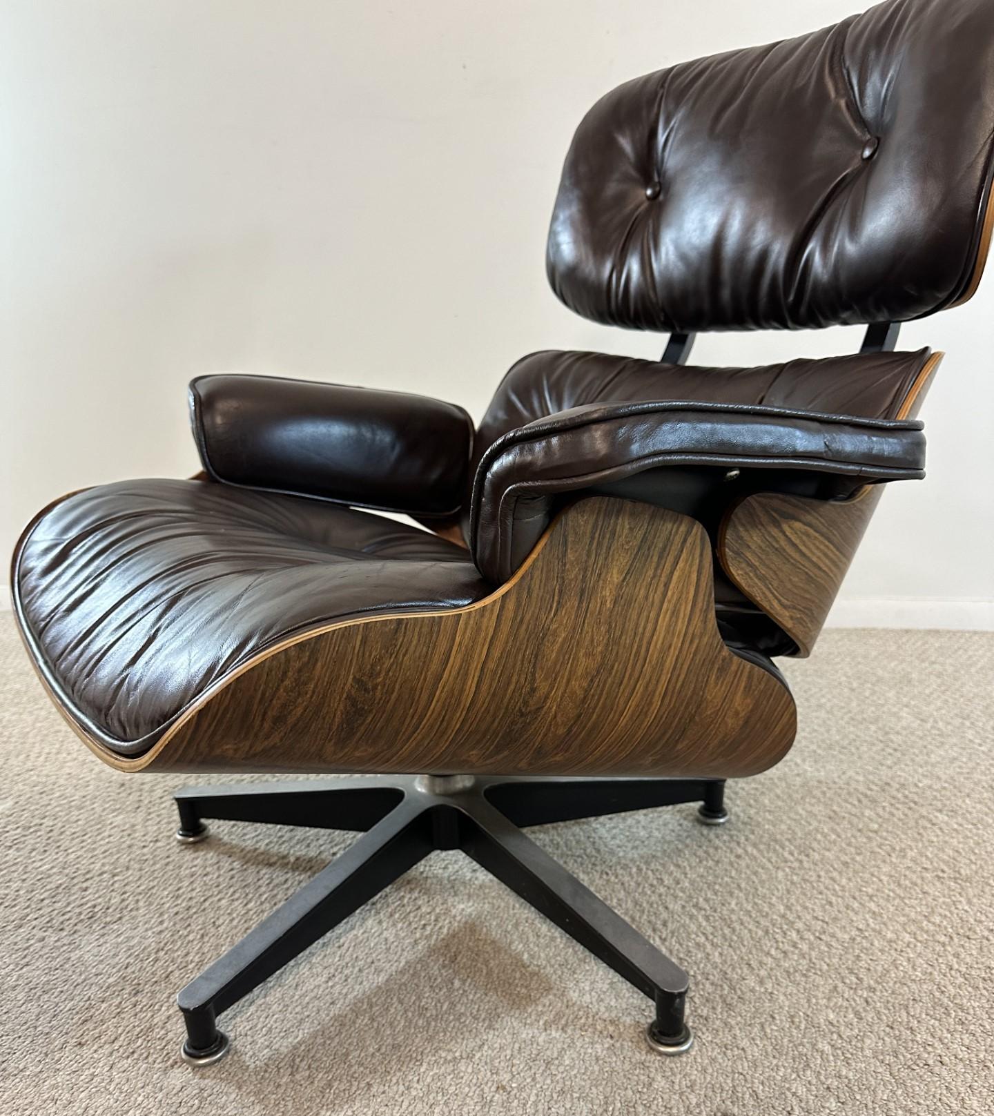 Herman Miller rosewood Eames lounge chair with ottoman. Rosewood lounge chair in brown leather. circa 1975. Some general wear to the leather. Wood has been repaired on the ottoman as photo'd. Dimensions: 32