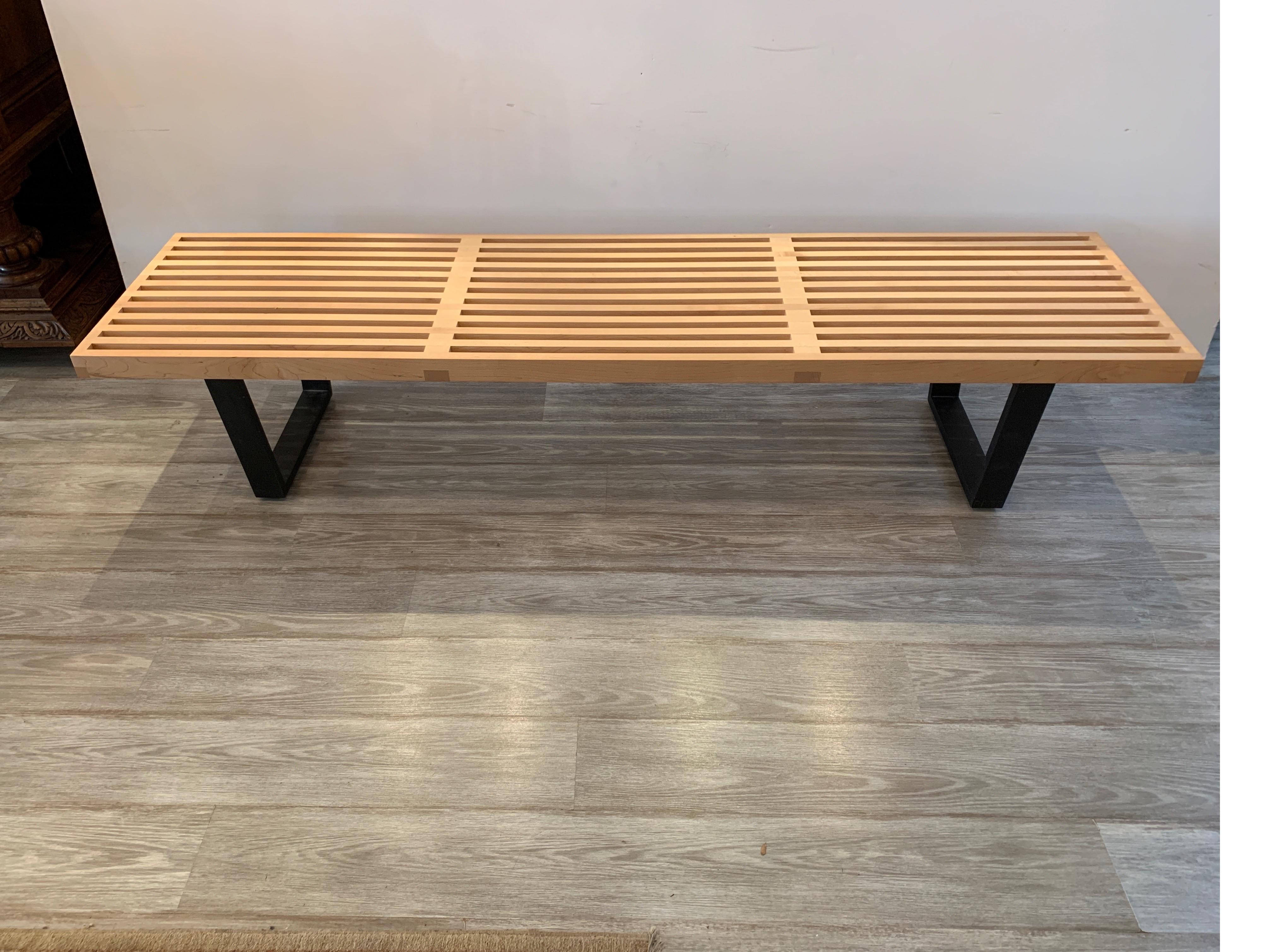 Iconic clean lined modern bench, designed by George Nelson for Herman Miller. This slat bench is constructed from natural solid maple and black lacquered wood base.