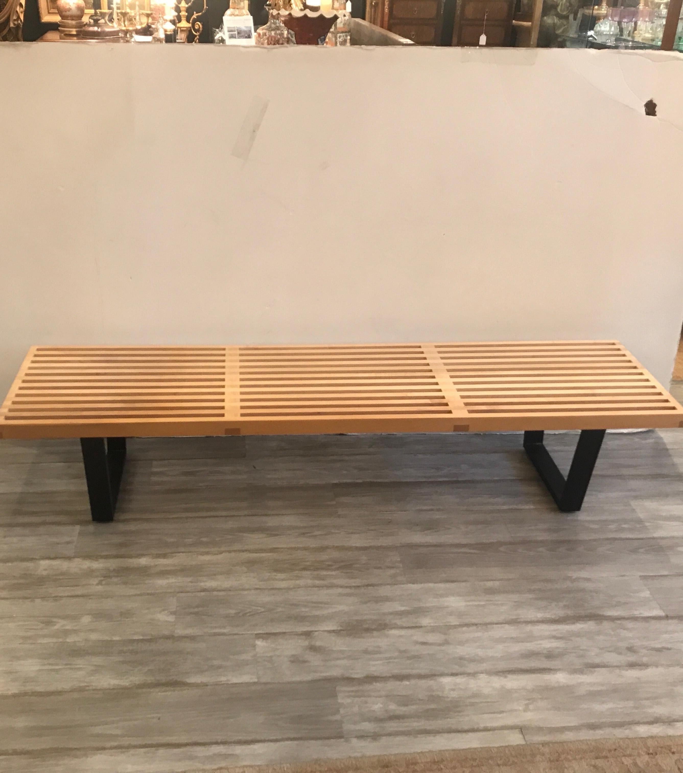 Iconic clean lined modern bench, designed by George Nelson for Herman Miller. This slat bench is constructed from natural solid maple and black lacquered wood base. Made in 2004.