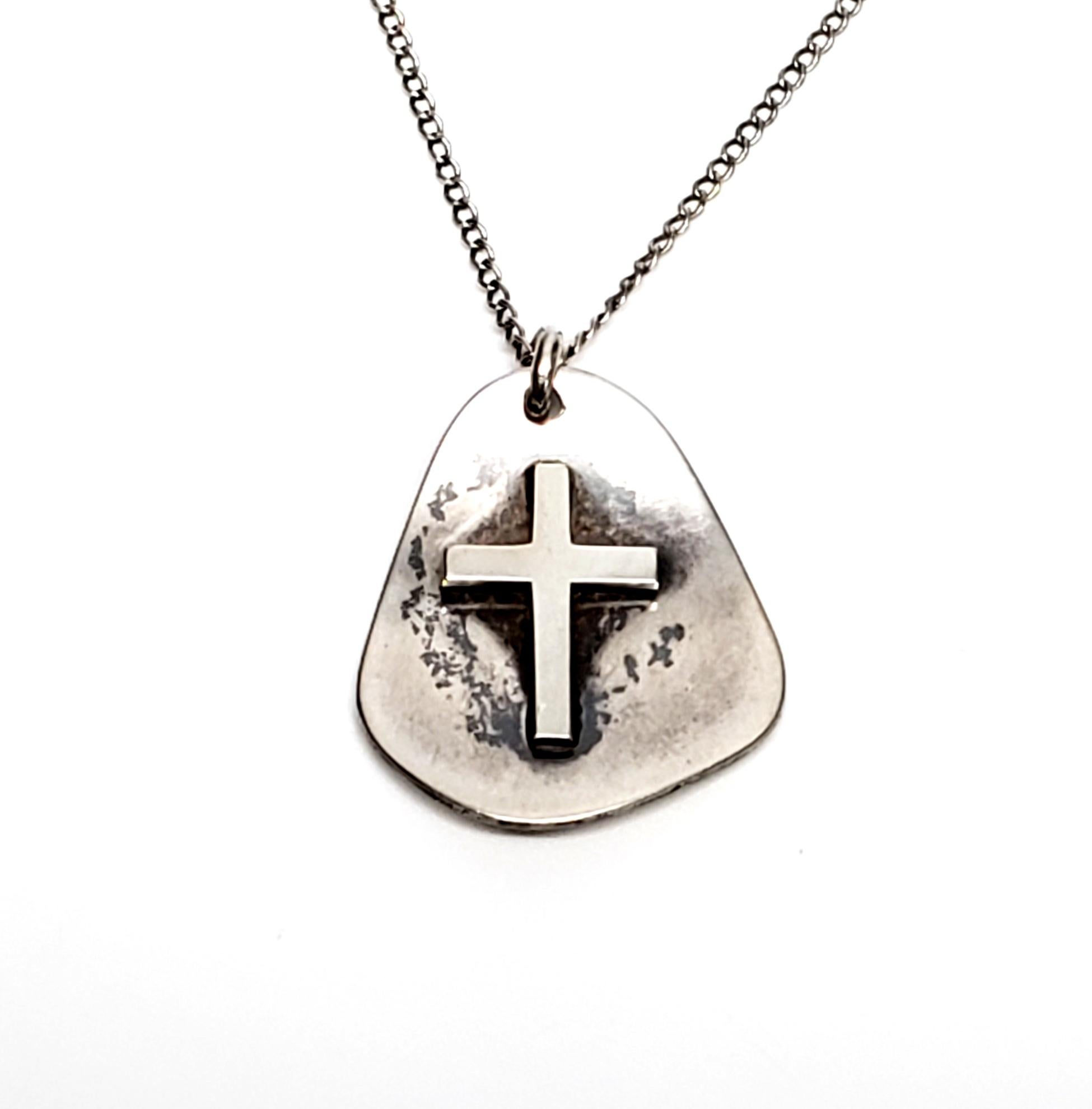 Vintage sterling silver cross pendant with a chain by Herman Roth.

Features an asymmetrical pendant with a cross on a thin chain.

Pendant measures 15/16