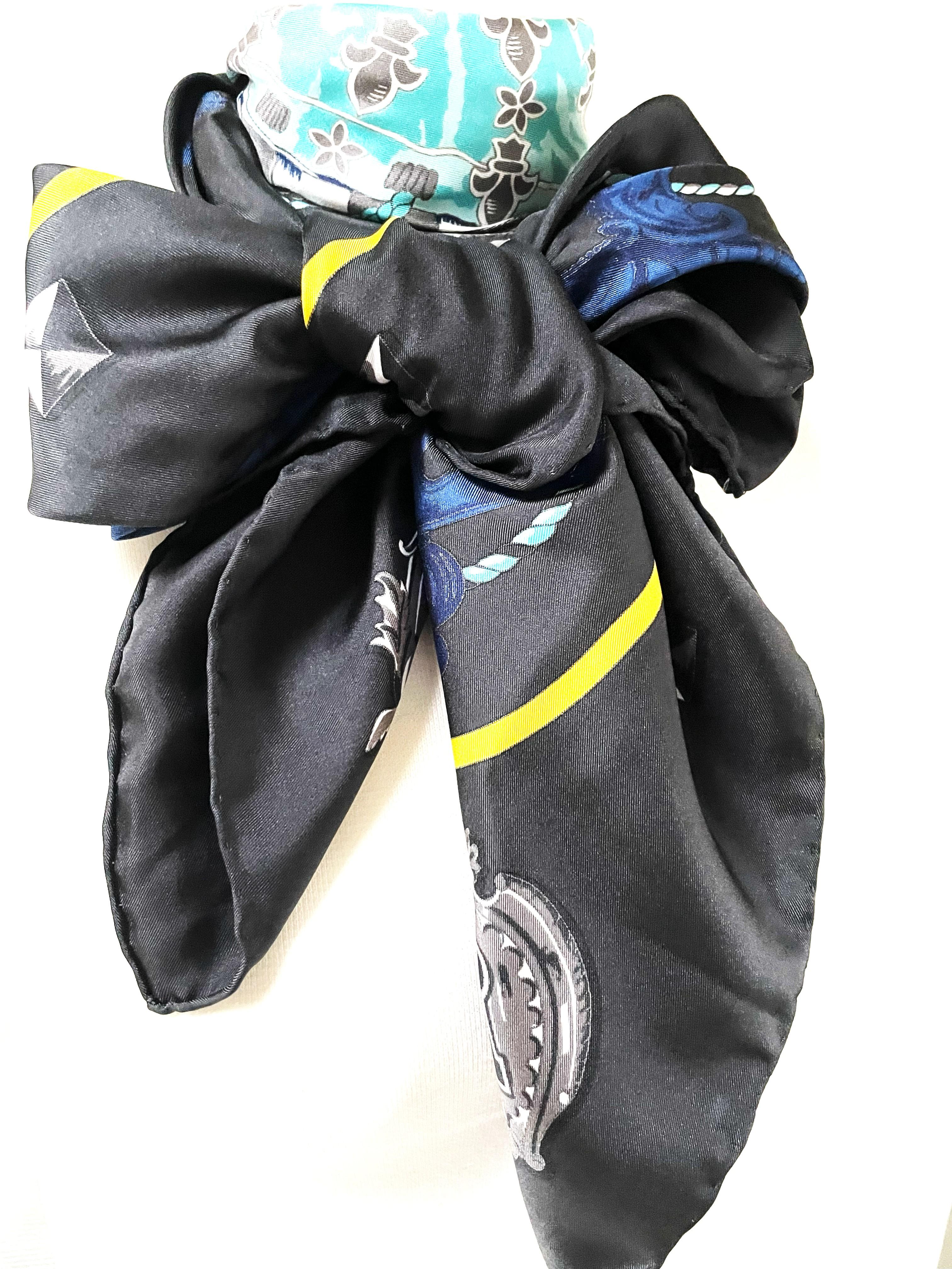 Hermes large 100 % silk scarf, 132 x 132 cm larg,  with blue and gray keys motives , hand-rolled by HERMÈS with a key motif on an anthracite-colored background. Turquoise colored cord with tassel runs through the whole cloth. A yellow stripe frames