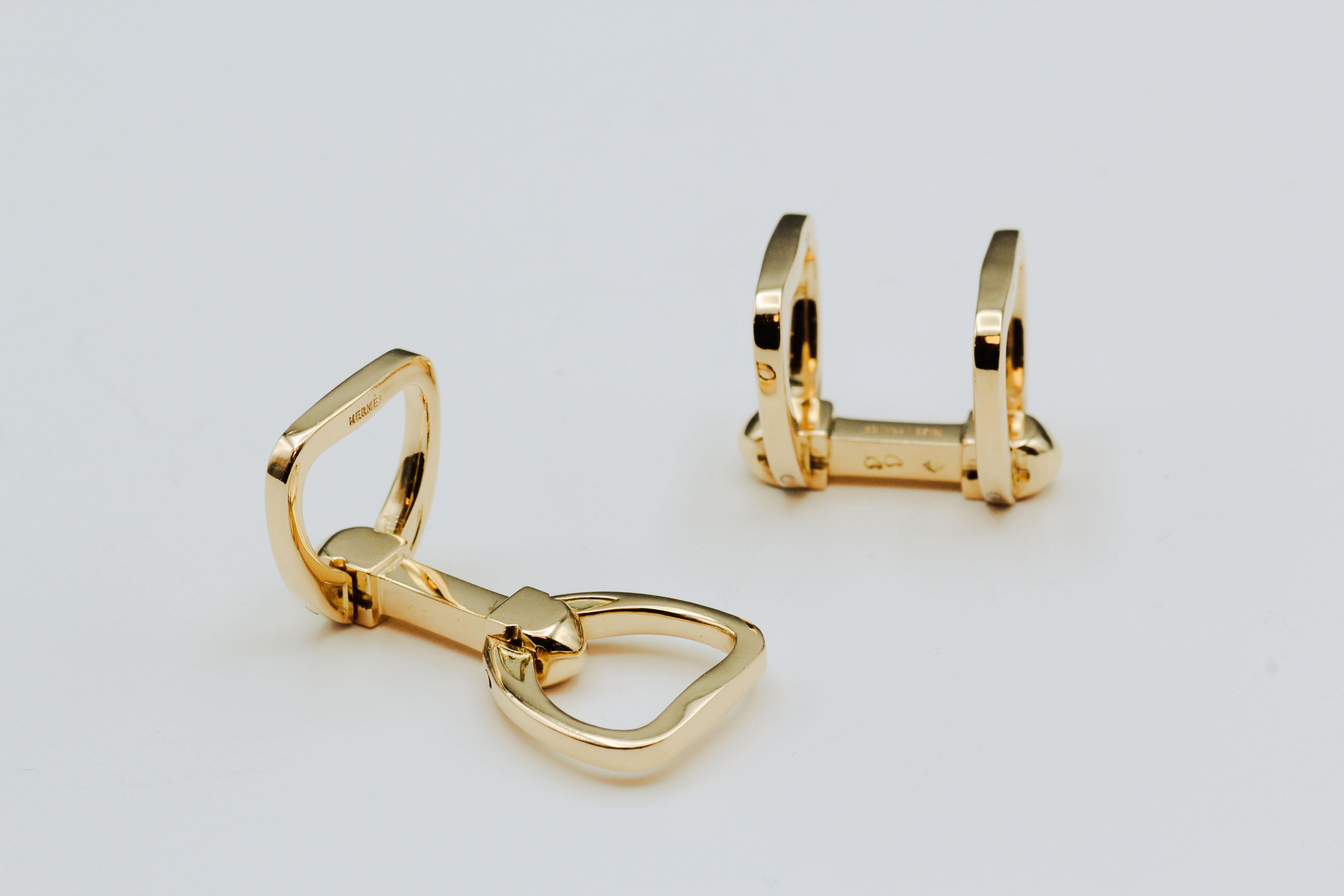 Fine pair of 18K yellow gold folding stirrup cufflinks by Hermes.  Circa 1980s.

Hallmarks: Hermes, maker's mark, French 18K gold assay mark.