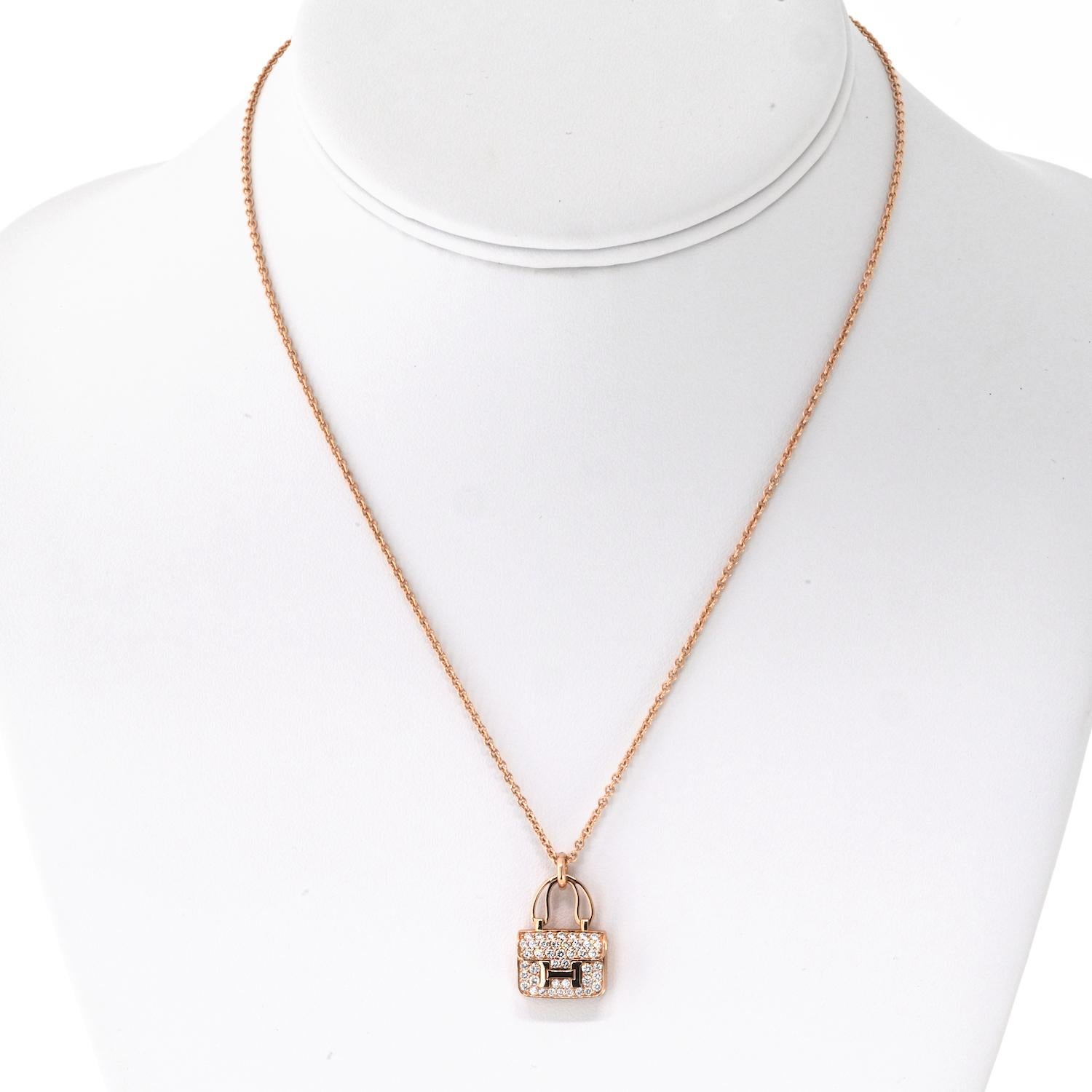 This Hermes 18k Rose Gold Amulettes Constance Pendant Necklace is a refined expression of elegance and luxury. 

Crafted in warm rose gold, the pendant features a stunning diamond-accented design with a signature Kelly snap closure, adding a touch