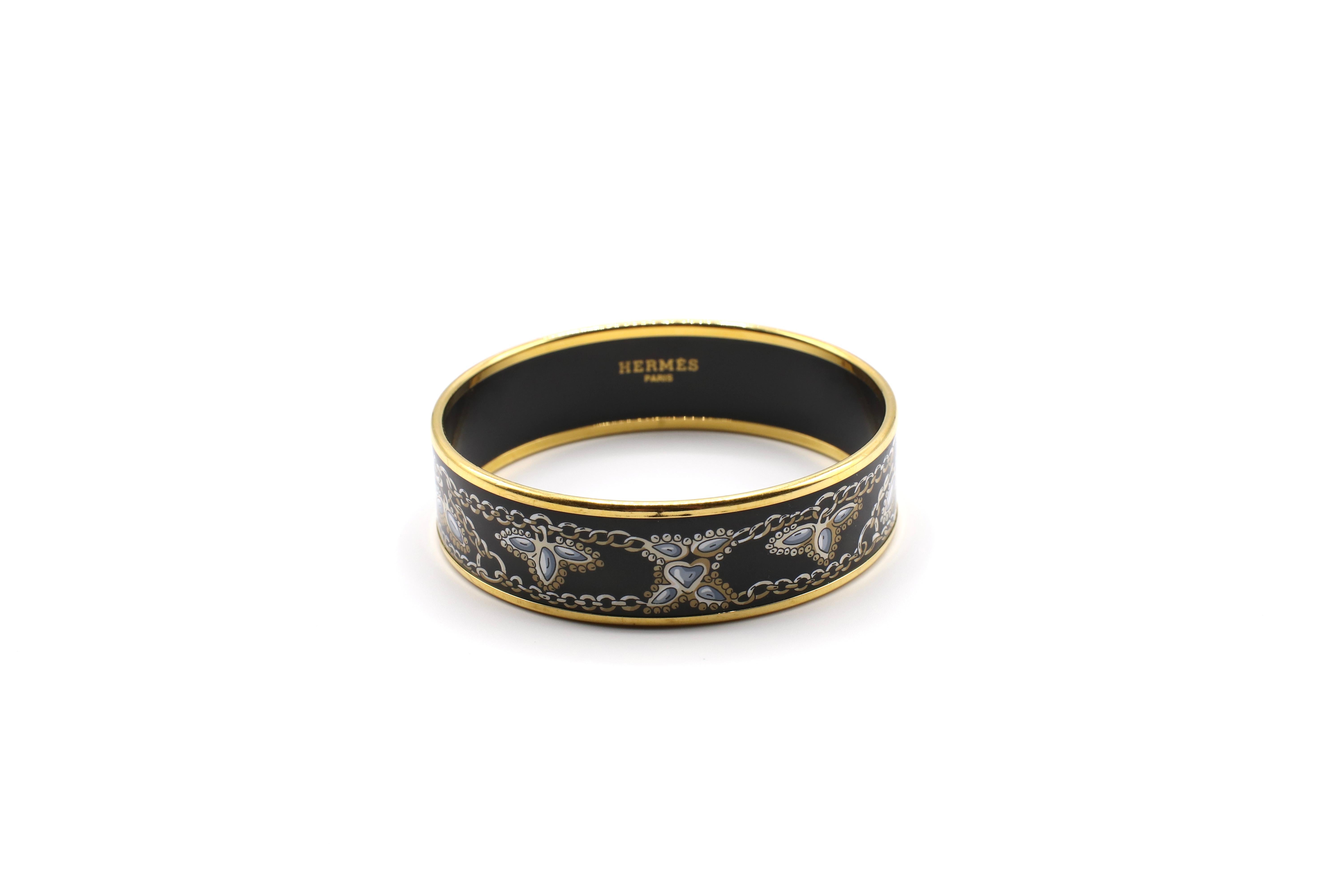 For sale is a Hermes Bangle Bracelet made of 18K Yellow Gold-Plate and Enamel in a Black and Gold Charm Bracelet Design. The bracelet fits approx a 6 inch wrist but can be tight fit because of it's thickness. The thickness is approx