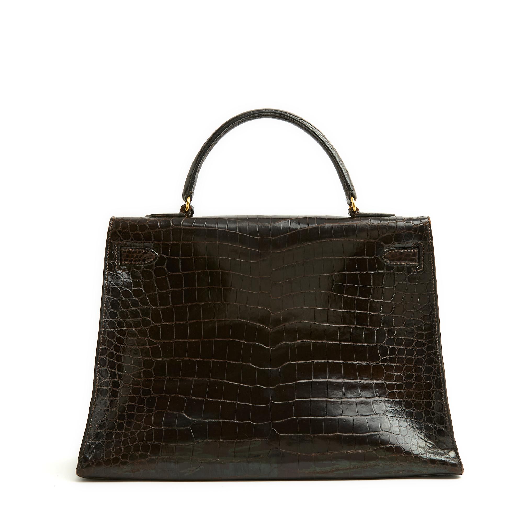 Bolso Hermès Kelly saddler, tamaño 35, de cocodrilo Porosus marrón oscuro y metal dorado, interior de piel con un bolsillo con cremallera en un lado y un bolsillo doble de parche en el otro, cremallera, timbre, llaves, candado forrado de piel a