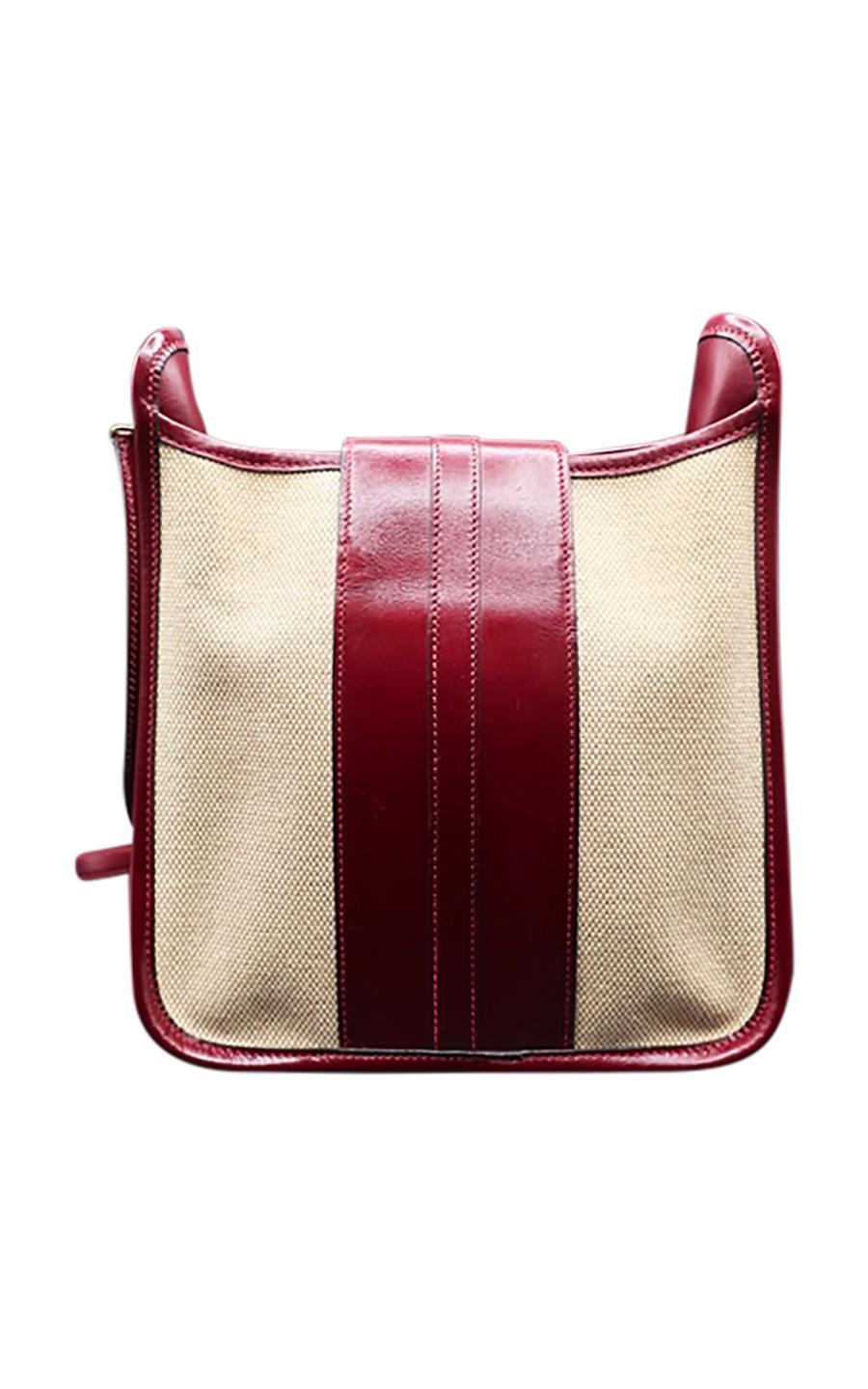 Vintage Hermès 1980 collection beige canvas and burgundy leather shoulder bag, in excellent pre-loved condition. Like the famous Evelyne model, it comes in a square, box shape, with a canvas body lined with burgundy-shade leather. It closes with a