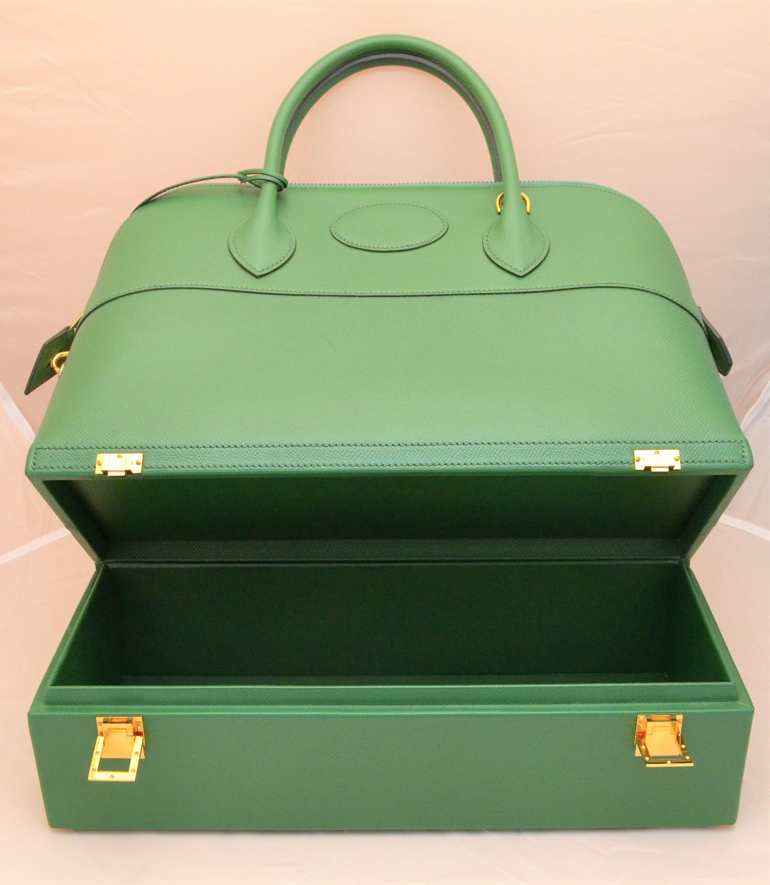 Ultra rare Hermes green Macpherson bag designed for supermodel, Elle Macpherson, features a structured top with a zipper and padlock closure, two handles, removable shoulder strap, and a separated compartment at the base of the bag with H latches.