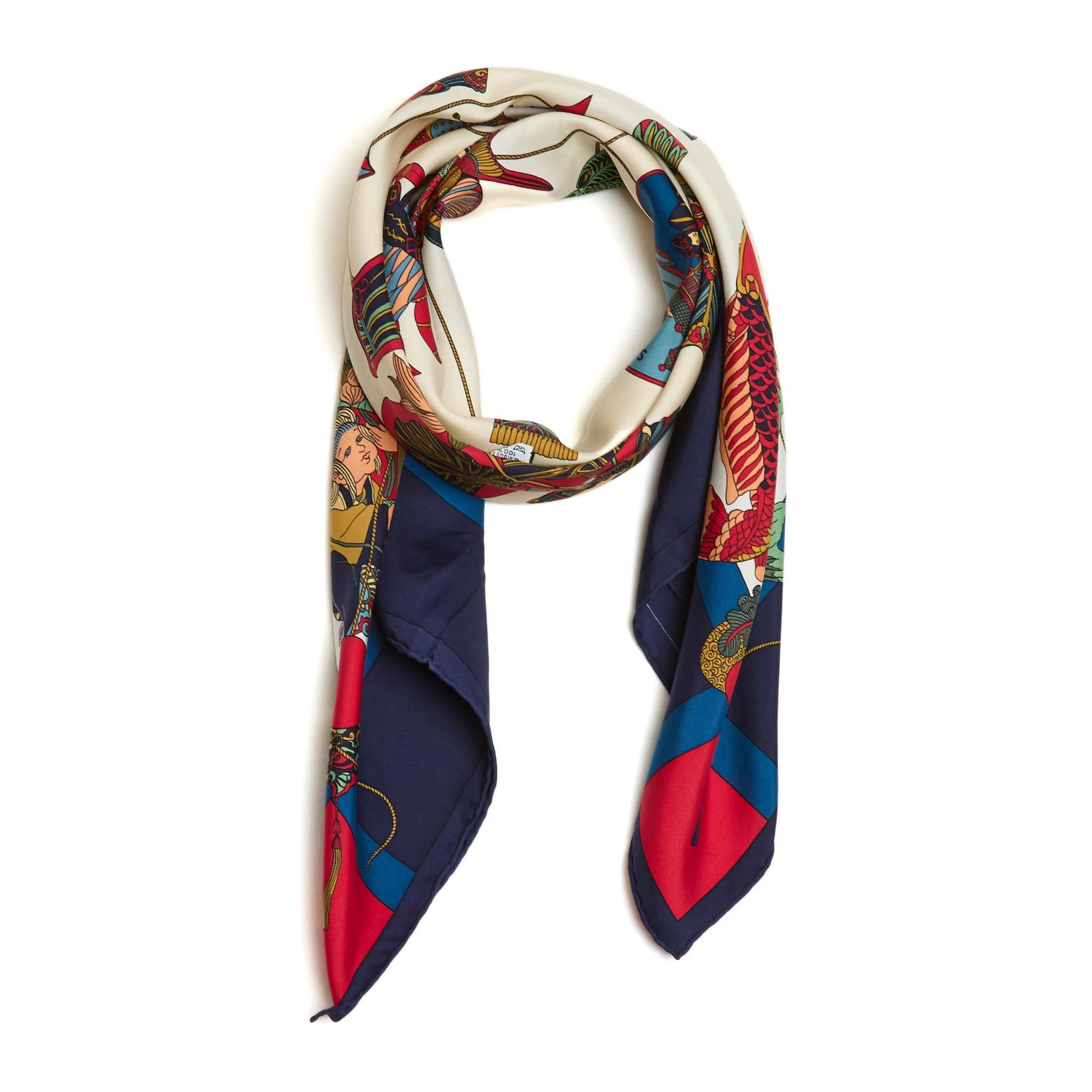 Hermès square scarf 90 in silk twill, Soies volantes pattern by Loïc Dubigeon, published in 1991, in shades of red and blue on ecru, navy blue edge. Width 90 cm x length 90 cm approximately. The square has been worn but it seems to be in excellent