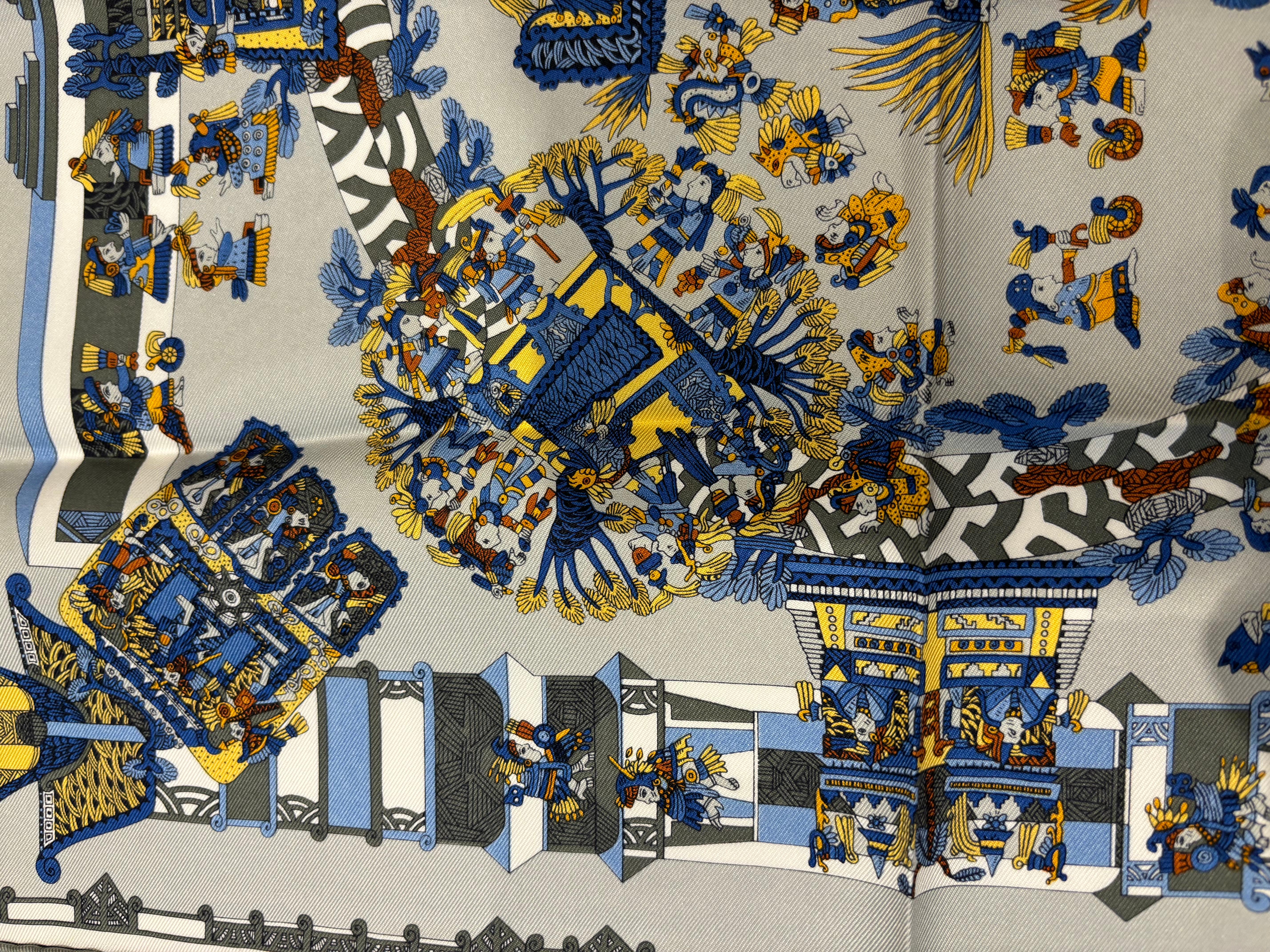 This a collector's Hermes scarf! The 1994 silk scarf designed by Anne Faivre is an hommage to ancient Inca civilization. The scarf predominantly features people in traditional dress in and around temples. There are also designs featuring animals,