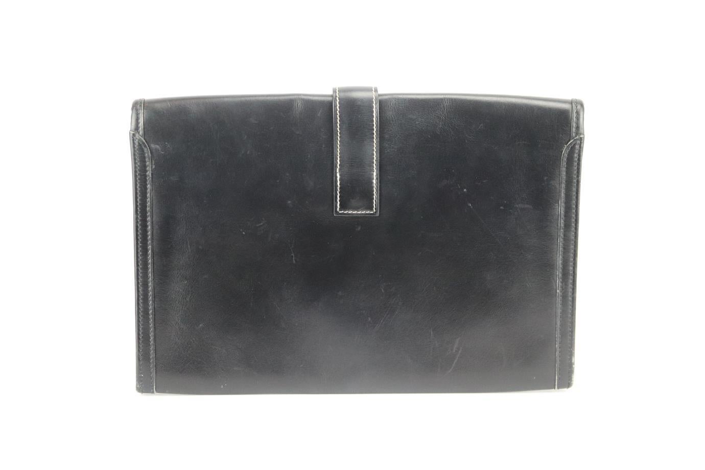 Hermès 1994 Jige 29cm box leather clutch. Made from black ‘Box’ leather with white contrast stitching tracing the edges, it has a large internal compartment with H flap at the front. Black. Slide lock fastening at front. Does not come with dustbag