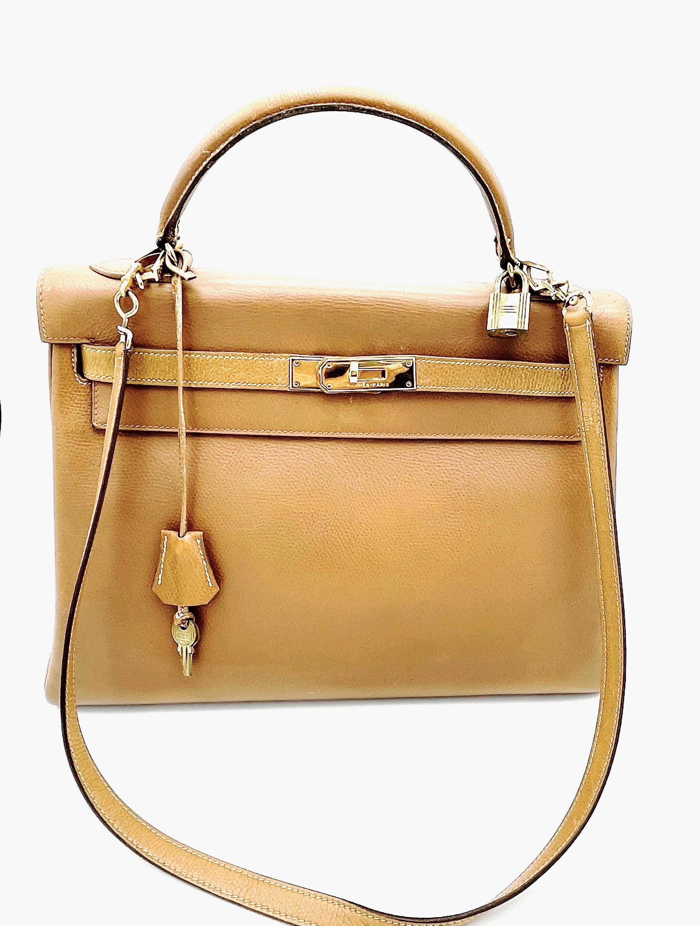 Hermés 2 way Kelly bag, Retourne, 32 cm, Curchevel leather in gold, Collection L in circle = 1982 with long autentic Strap, Lock and Key and Hermes dustbag. 
The bag has been revised and is again in good condition. Interior with 3 compartments,