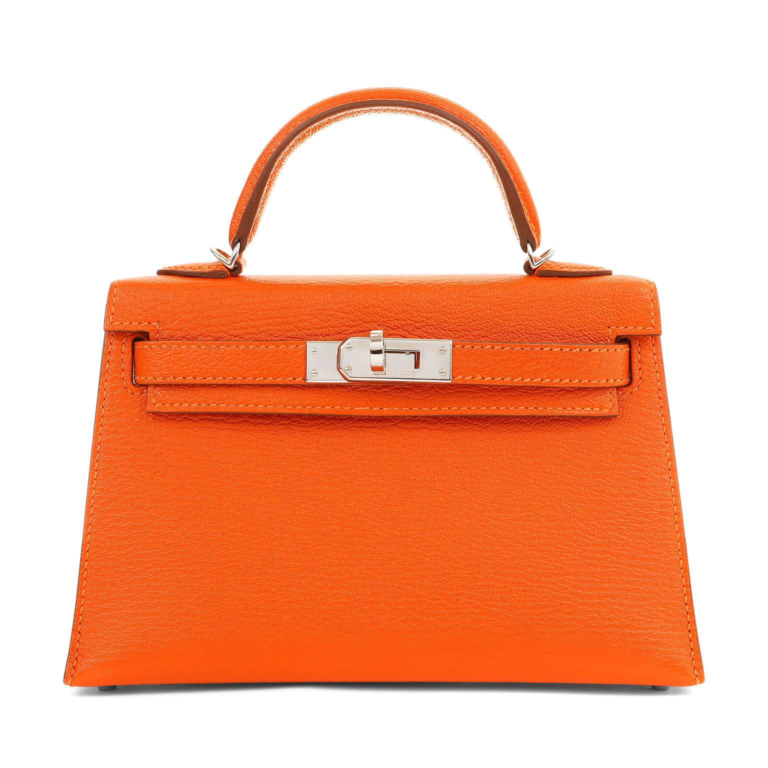 This authentic Hermès 20 cm Orange Chevre Mini Kelly is in pristine condition. Petite and feminine, the crossbody Kelly is very rare in the 20 cm silhouette.
Intense orange chevre leather is extremely durable and desirable.  Sophisticated Palladium
