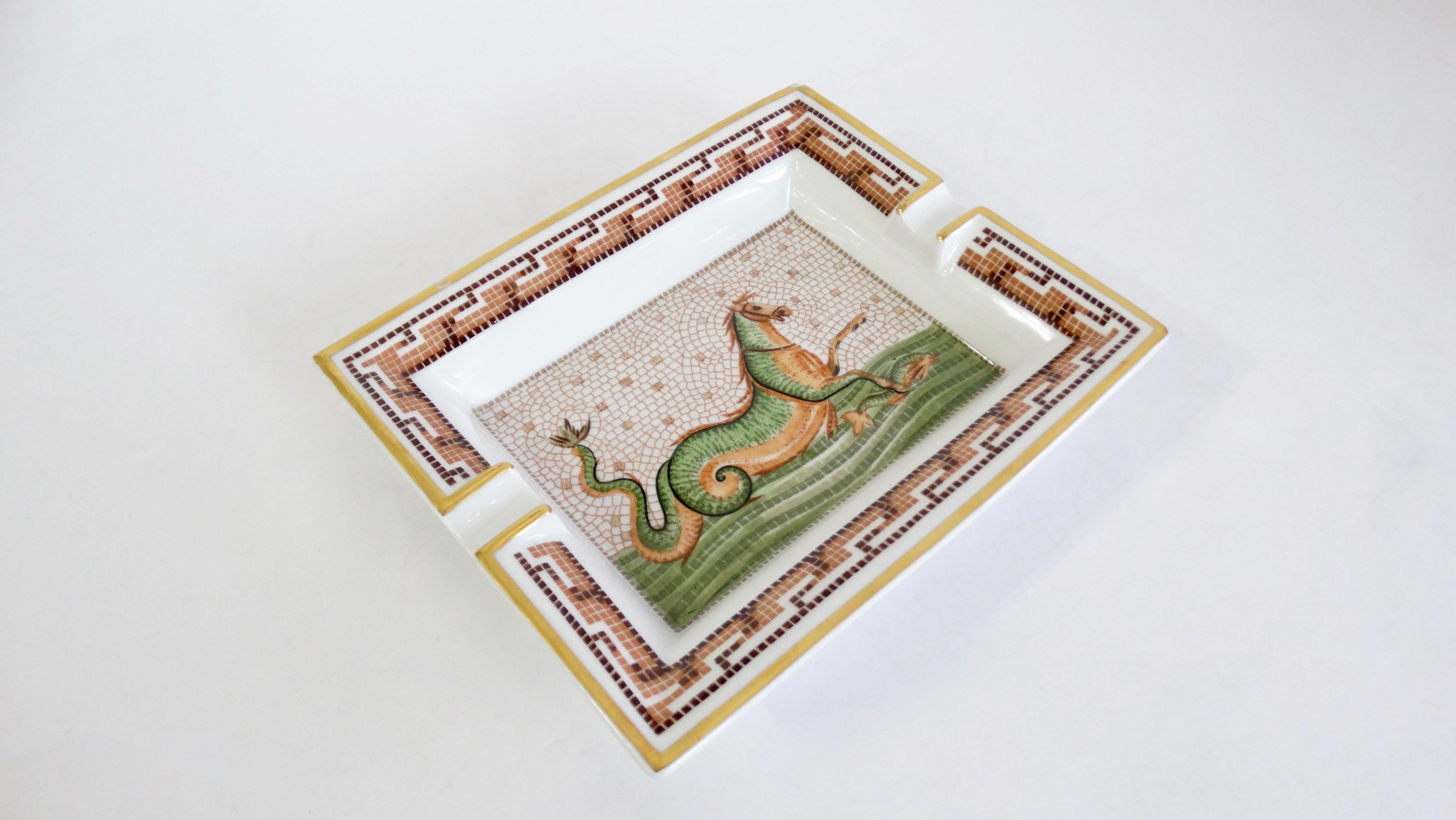 Decorate in style with this amazing Hermés tray! Circa 2000s, this tray is crafted from porcelain and features a mosaic Hippocamp motif derived from Greek mythology. Trim is painted in metallic gold and includes a decorative mosaic pattern framing