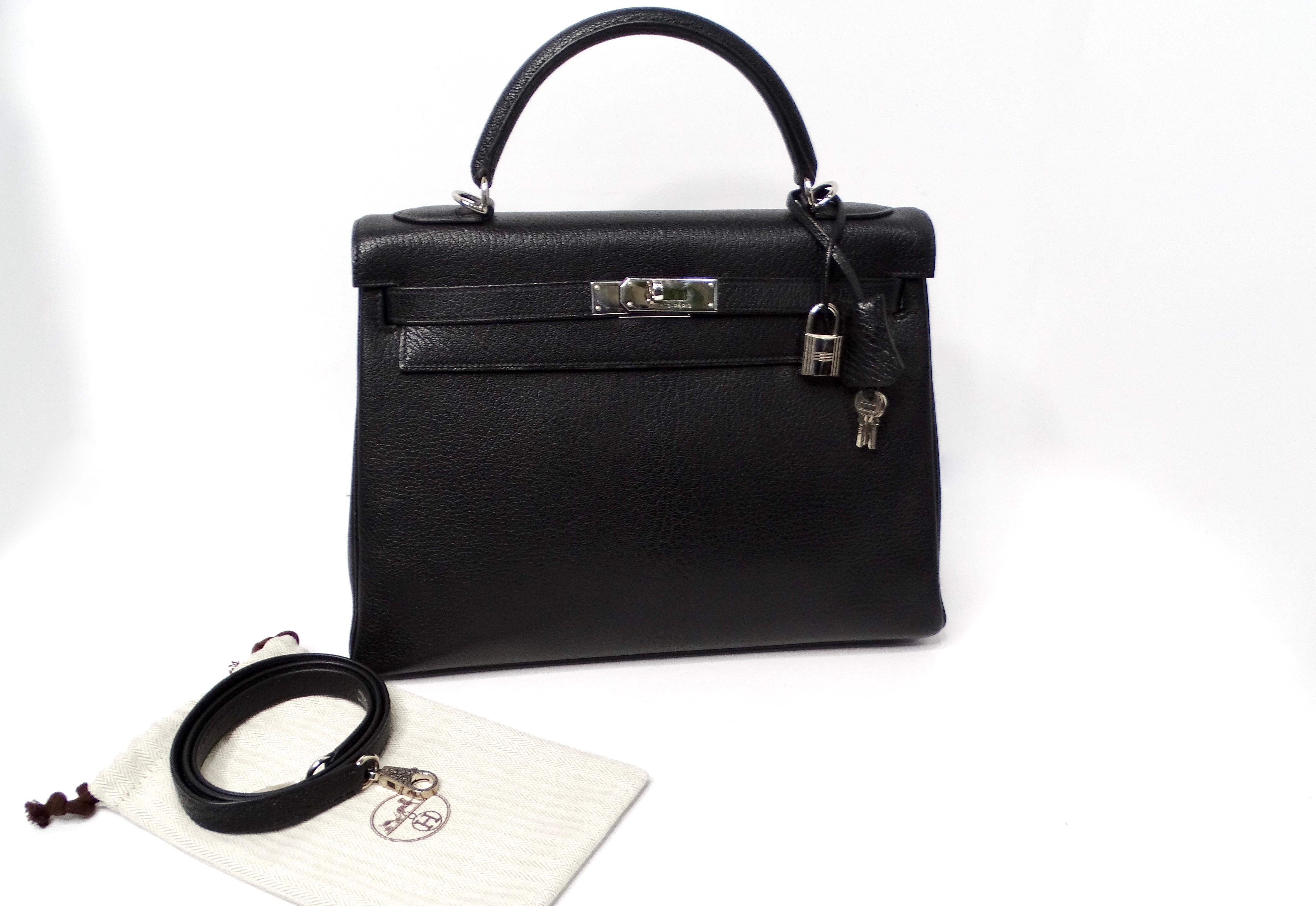 The Hermès 2003 Kelly 32cm G Square in Chèvre Coromandel leather is a remarkable representation of luxury craftsmanship. Featuring a chic black goat leather exterior, this bag showcases the distinct spine characteristic of male goatskin, elevating