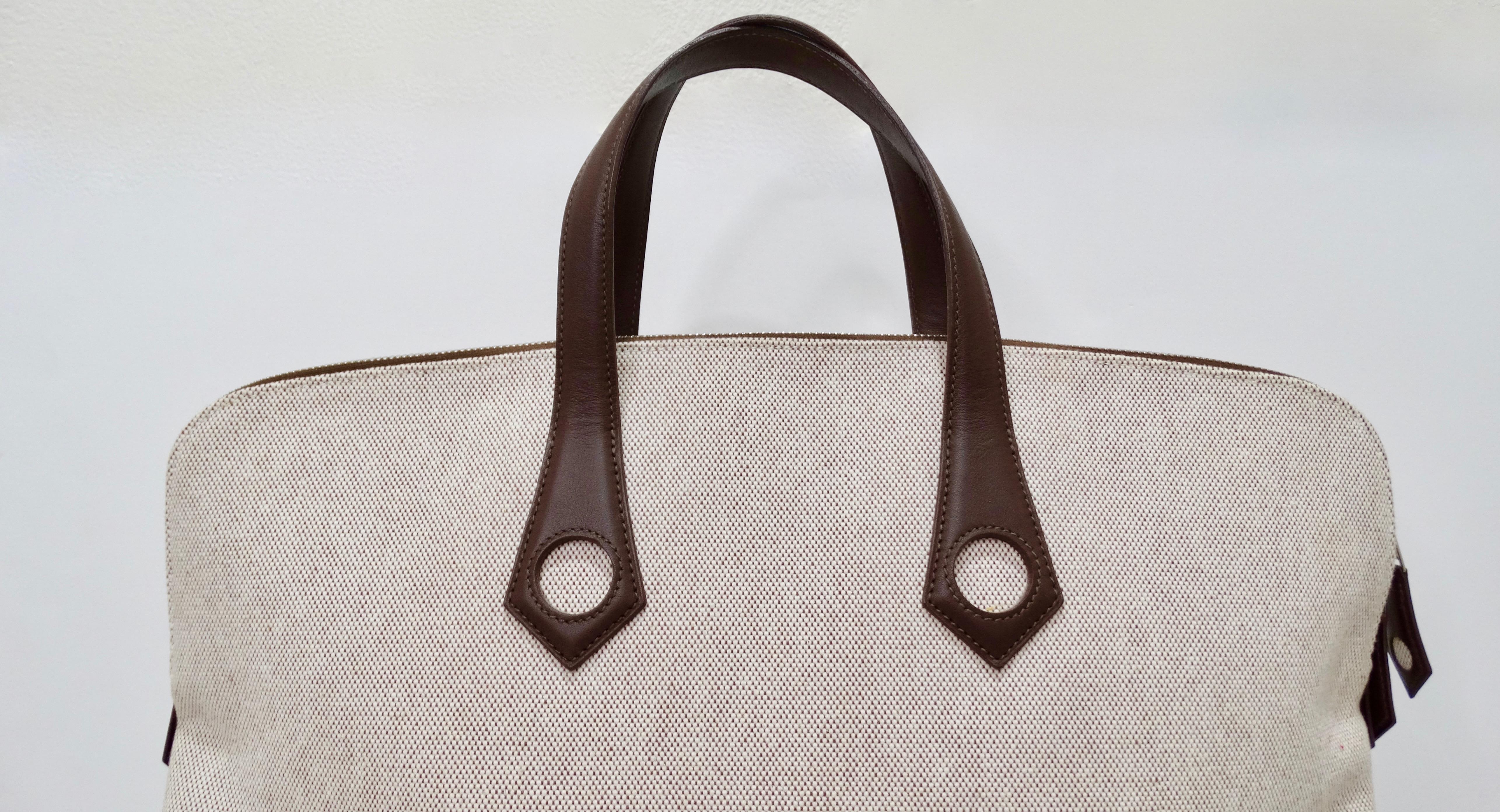 Hello Hermés lovers! Circa 2006, this large travel tote is crafted from tan and brown woven canvas and features pristine chocolate stitching, dual chocolate leather top handles with circle cutouts, tonal leather pipping, silver tone hardware and a