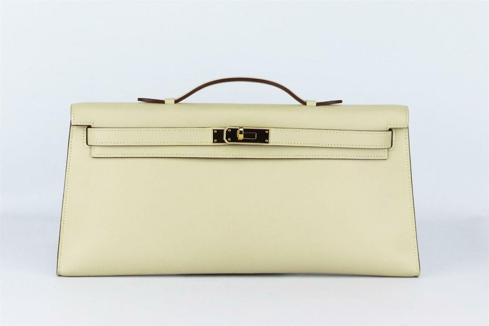 Made in France, this beautiful 2008 Hermès ‘Kelly Longue’ clutch bag has been made from ‘Swift’ leather in a subtle light beige hue and matching leather interior, this piece is decorated with gold hardware on the front and finished with top